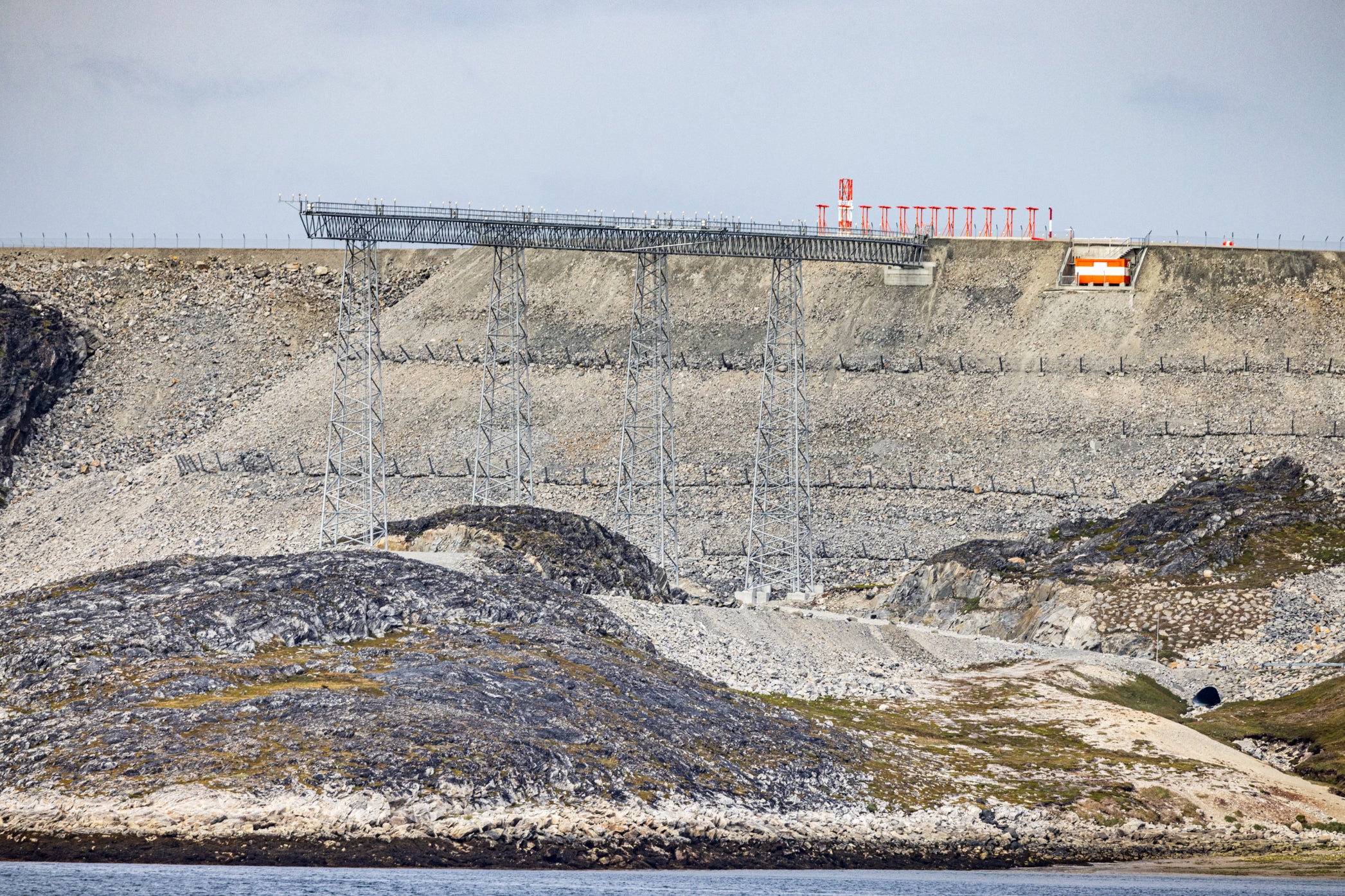 The runway at the airport in Nuuk is placed on a plateau over the city and the landing lights are placed on a tall scaffold at each end