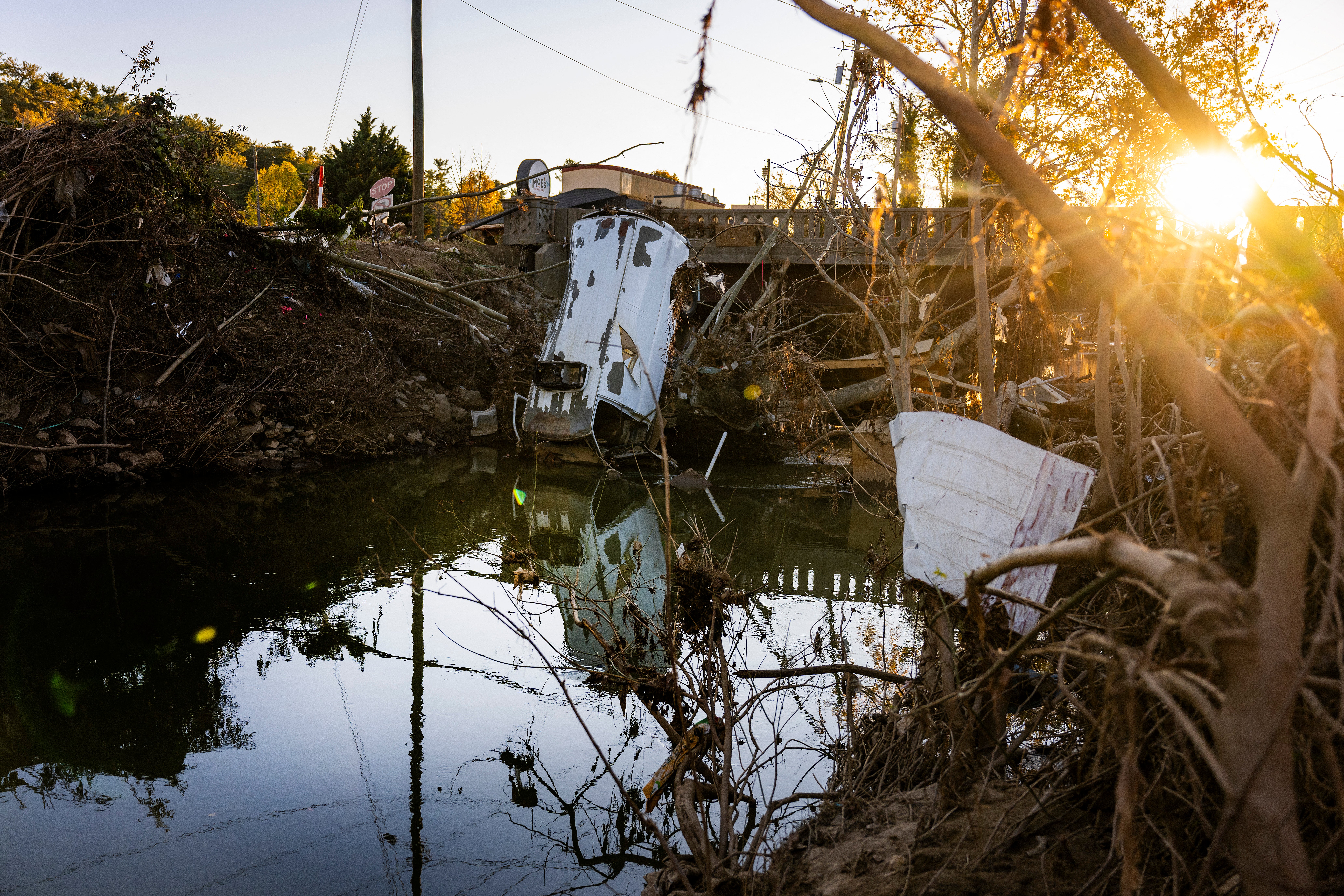 A van stands sunken with other debris in the Swannanoa River in Asheville, North Carolina, on October 20, as clean-up efforts continue after Hurricane Helene devastated the area. Trump visited the area on Monday