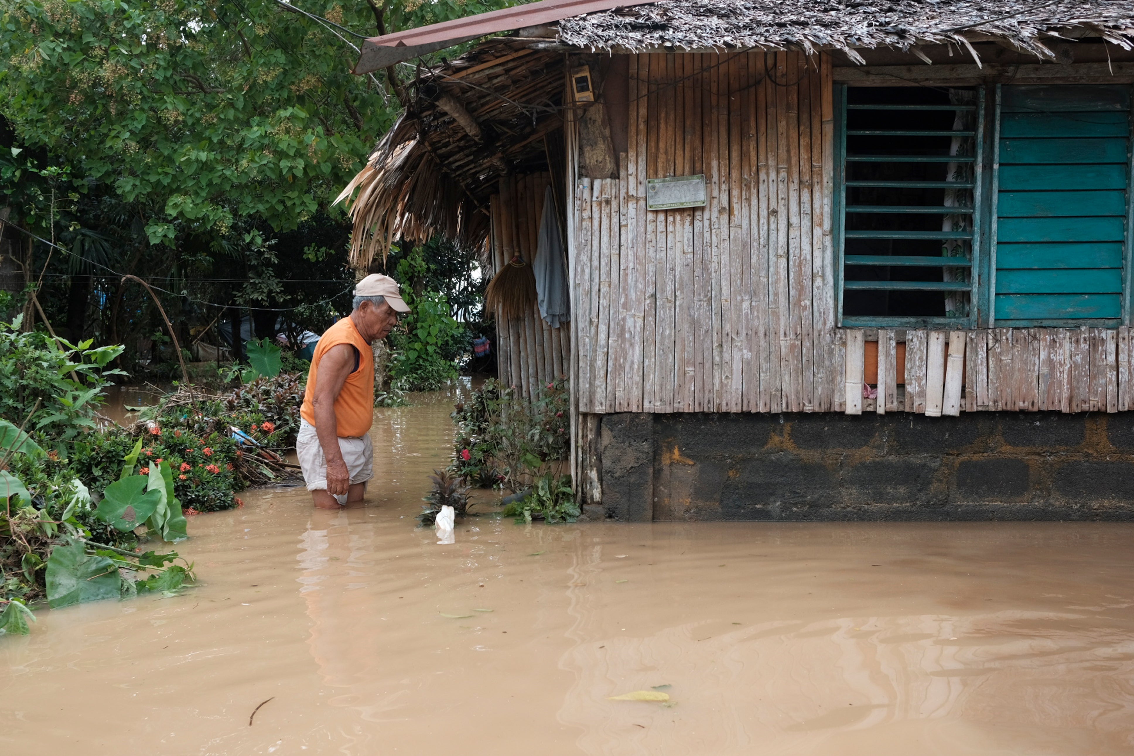 A man wades through floodwaters outside his house in Polangui, Philippines, on 23 October 2024