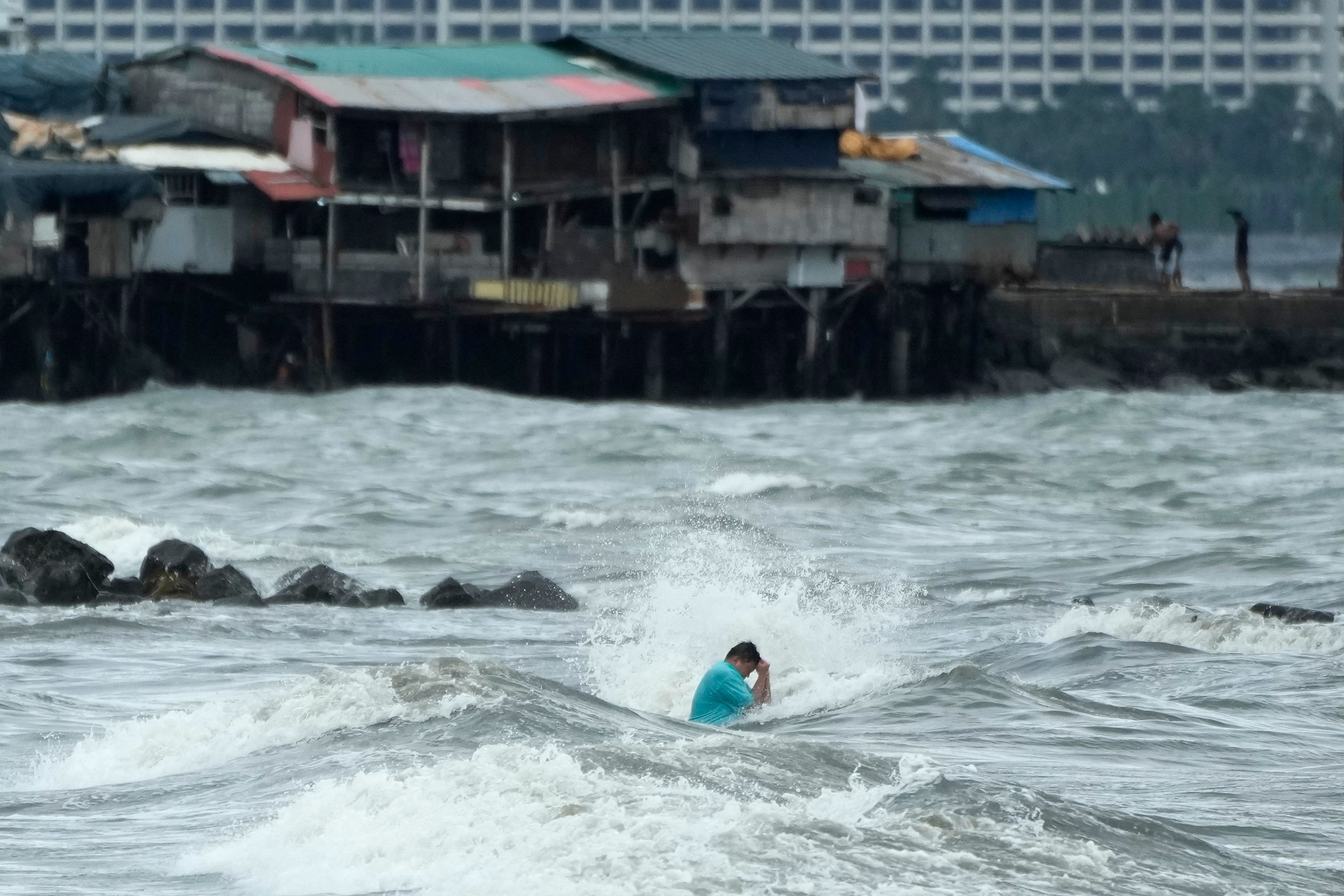 A resident swims in strong waves caused by Trami in Manila, Philippines, on 23 October 2024