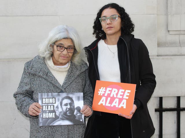 <p>Laila Soueif, 68, stands next to her daughter Sanaa Seif in London holding signs calling for the release of Alaa Abdel Fattah </p>