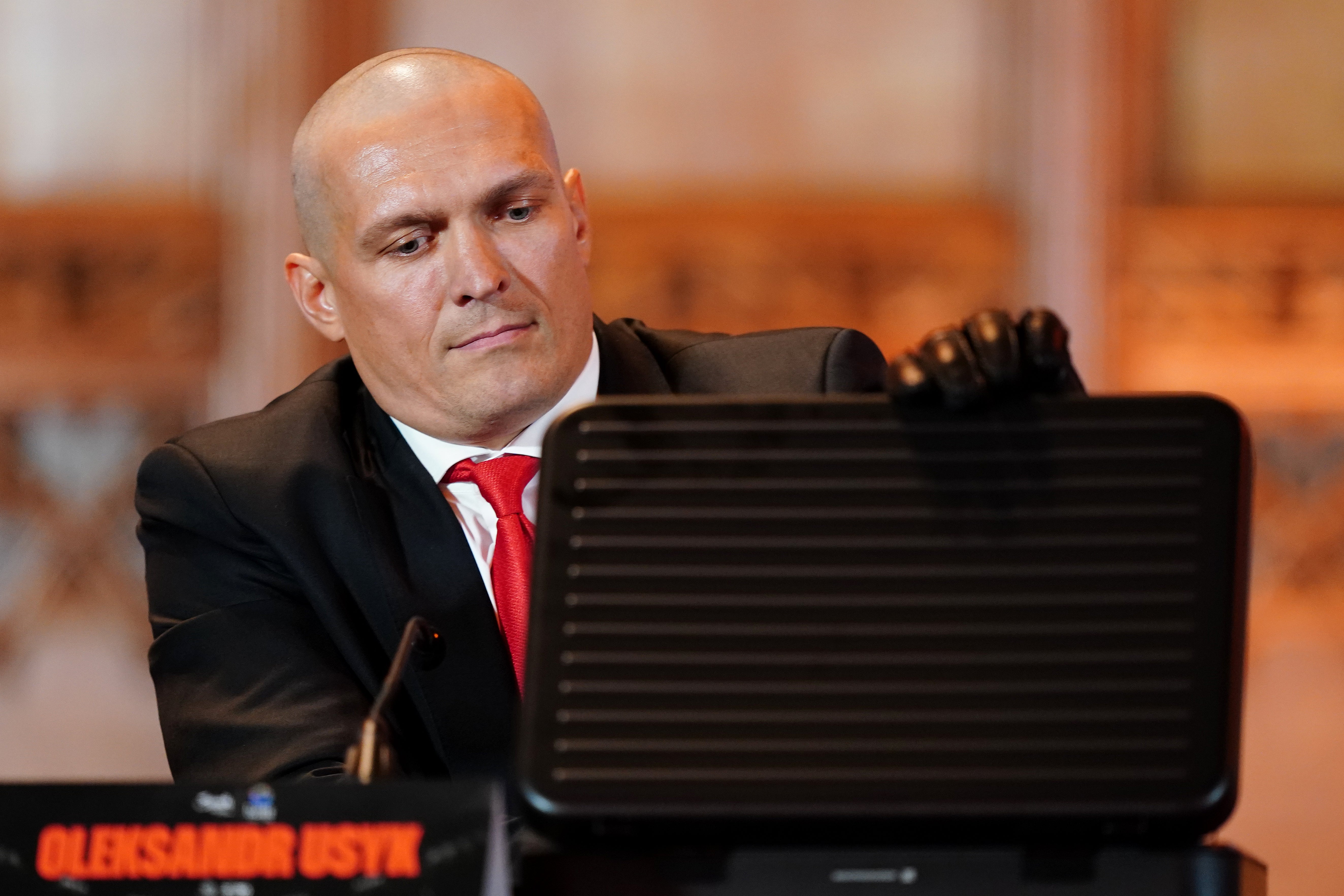 Oleksandr Usyk opens a briefcase at the Guildhall, London