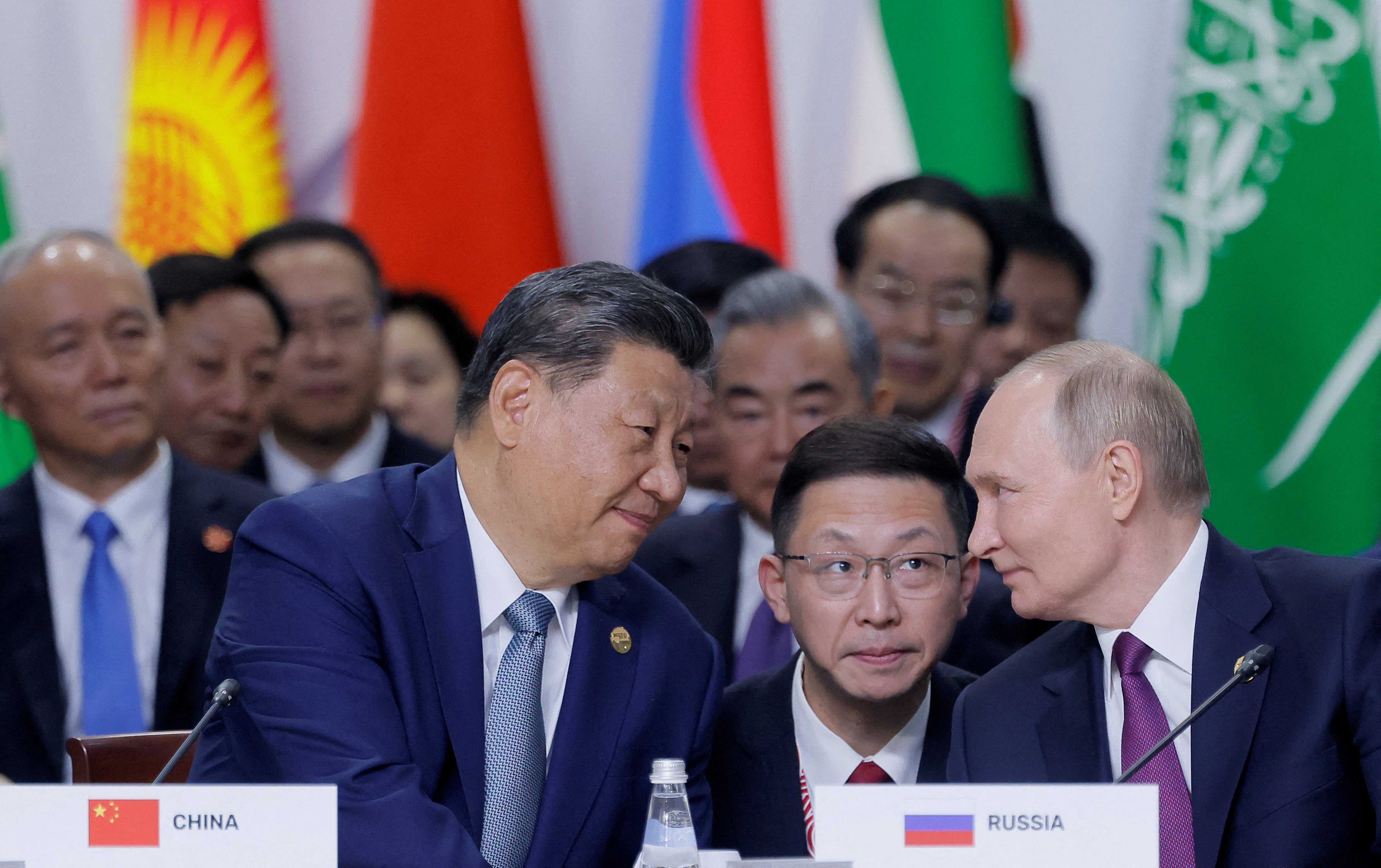 Russian President Vladimir Putin and Chinese President Xi Jinping speak during a plenary session in the outreach/BRICS Plus format