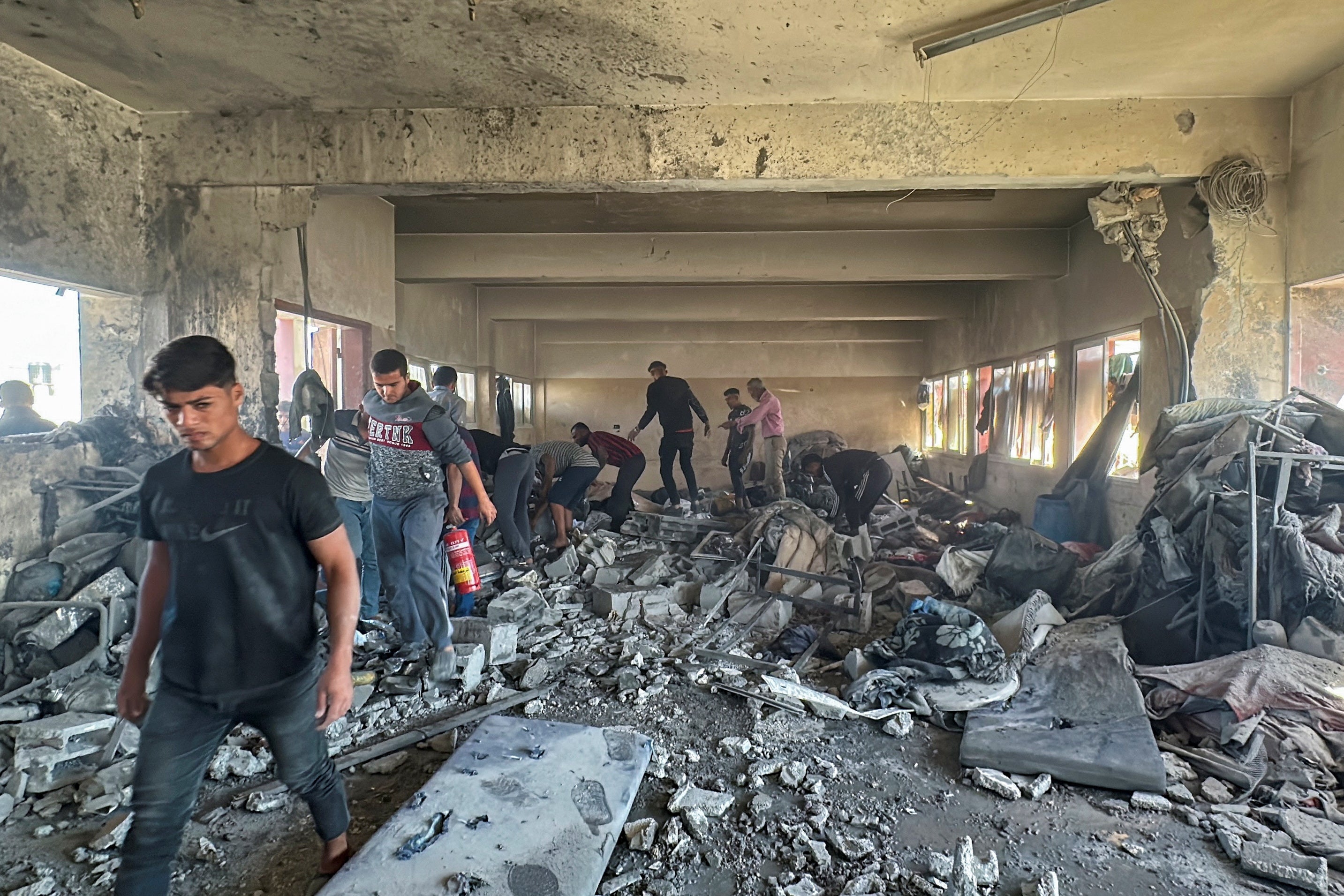 Palestinians inspect the aftermath of the attack on a school that was housing displaced people