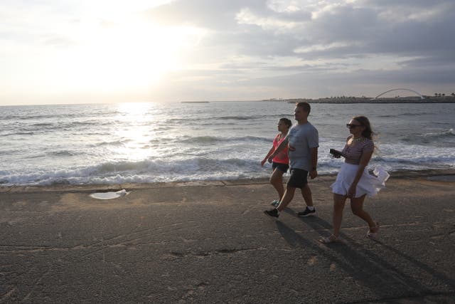 <p>Foreign tourists spend the evening at the Galle Face beachfront in Colombo, Sri Lanka</p>