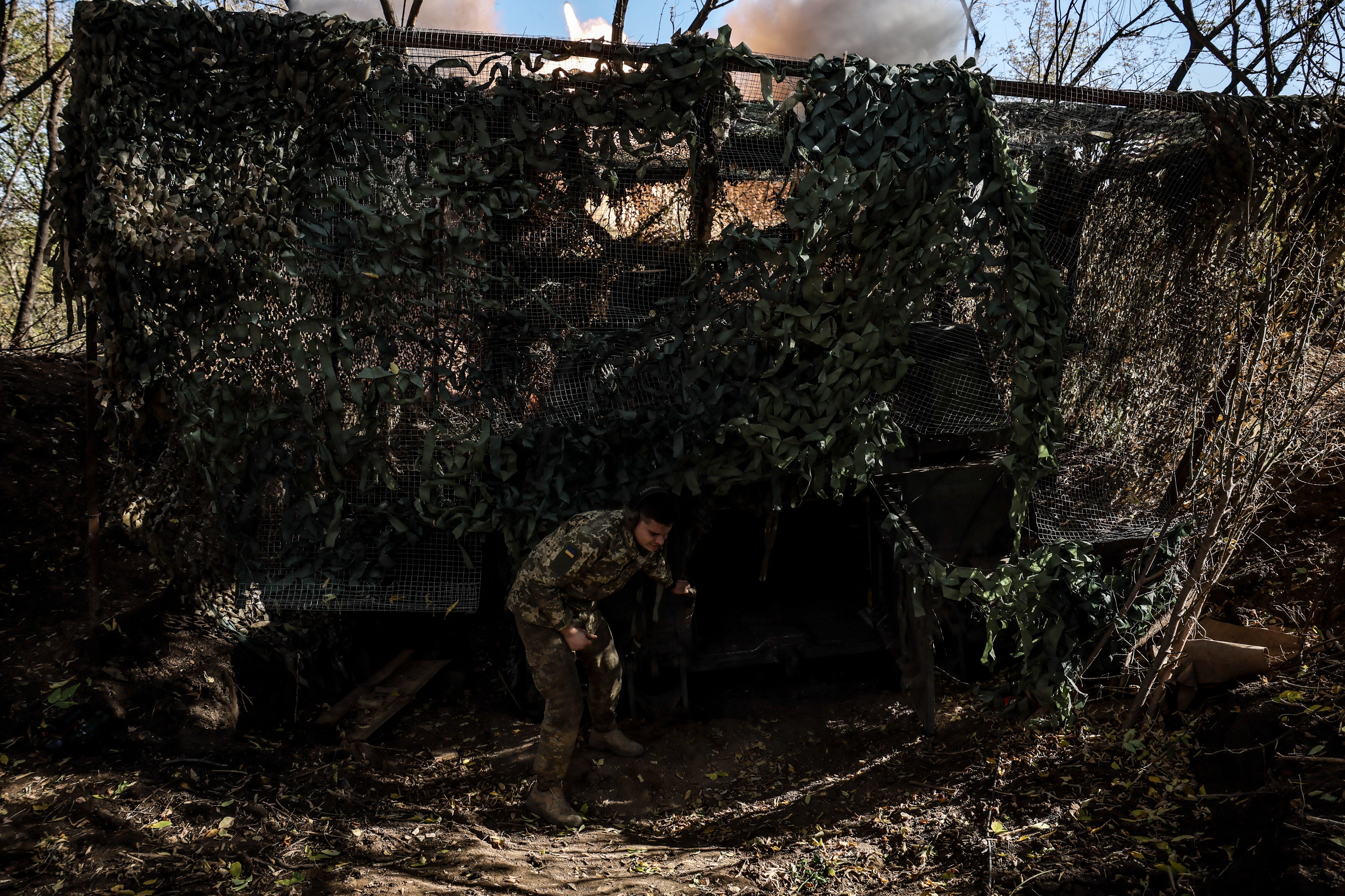 This handout photograph released by the Press Service of the 24 Separate Mechanized Brigade, shows Ukrainian servicemen of the 24 Separate Mechanized Brigade in action as they fire a howitzer on a position near Chasiv Yar, in the Donetsk region