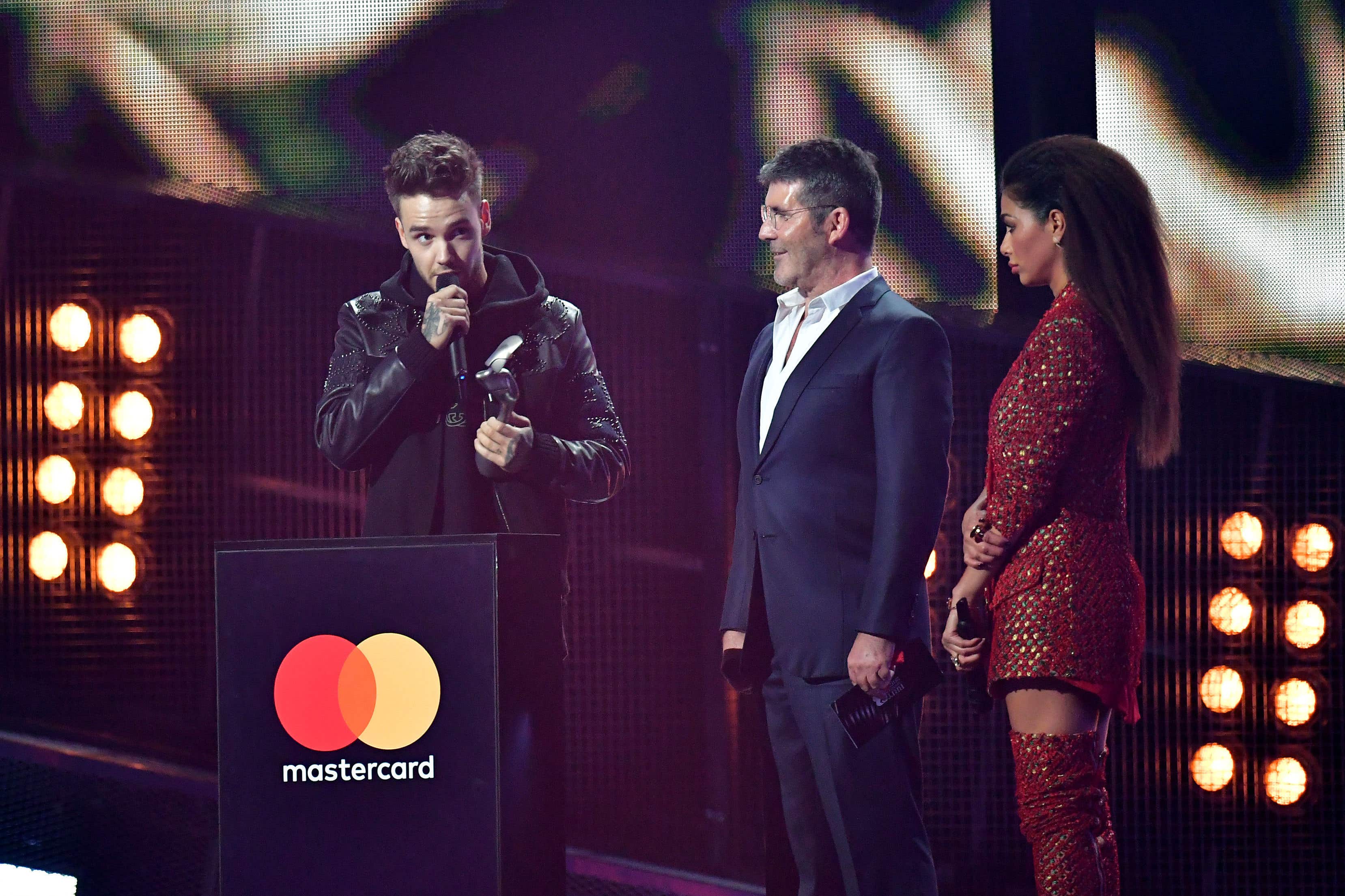 Nicole Scherzinger and Simon Cowell look on as Liam Payne collects his award for One Direction at the Brit Awards in 2017 (Dominic Lipinski/PA)