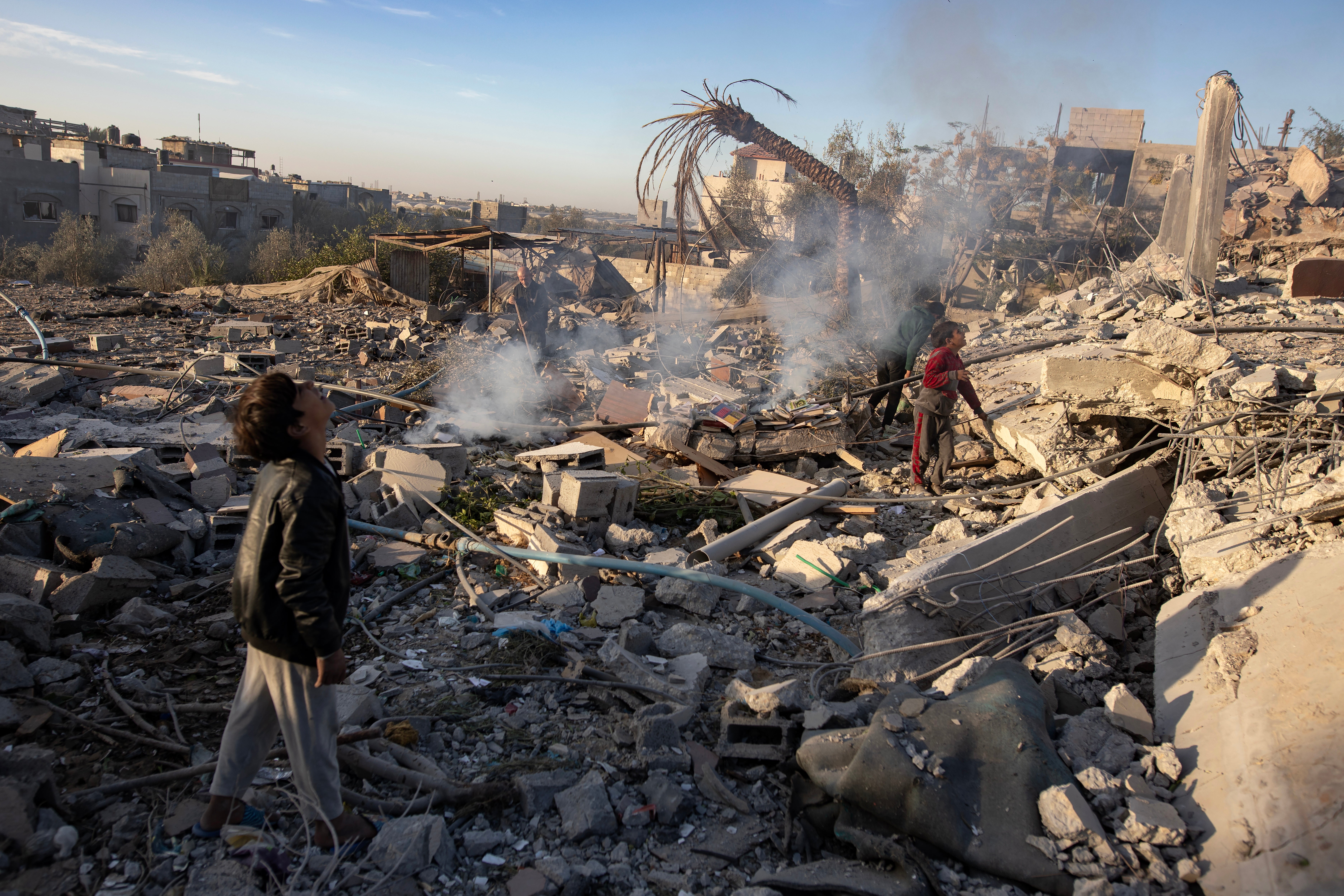 Palestinians inspect the rubble following the airstrike on Khan Younis