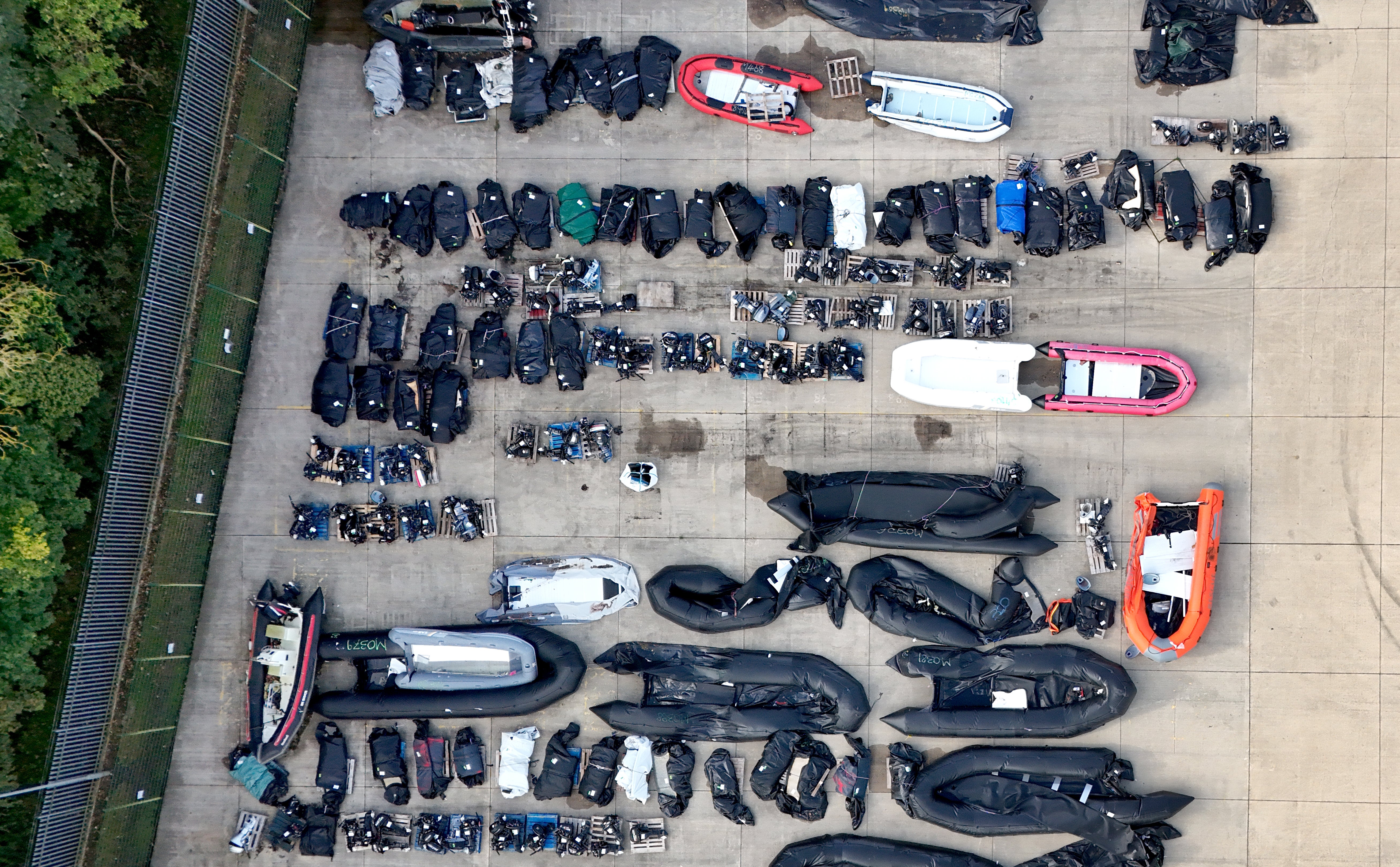 A view of small boats and outboard motors used by people thought to be migrants to cross the Channel at a warehouse facility in Dover, Kent.