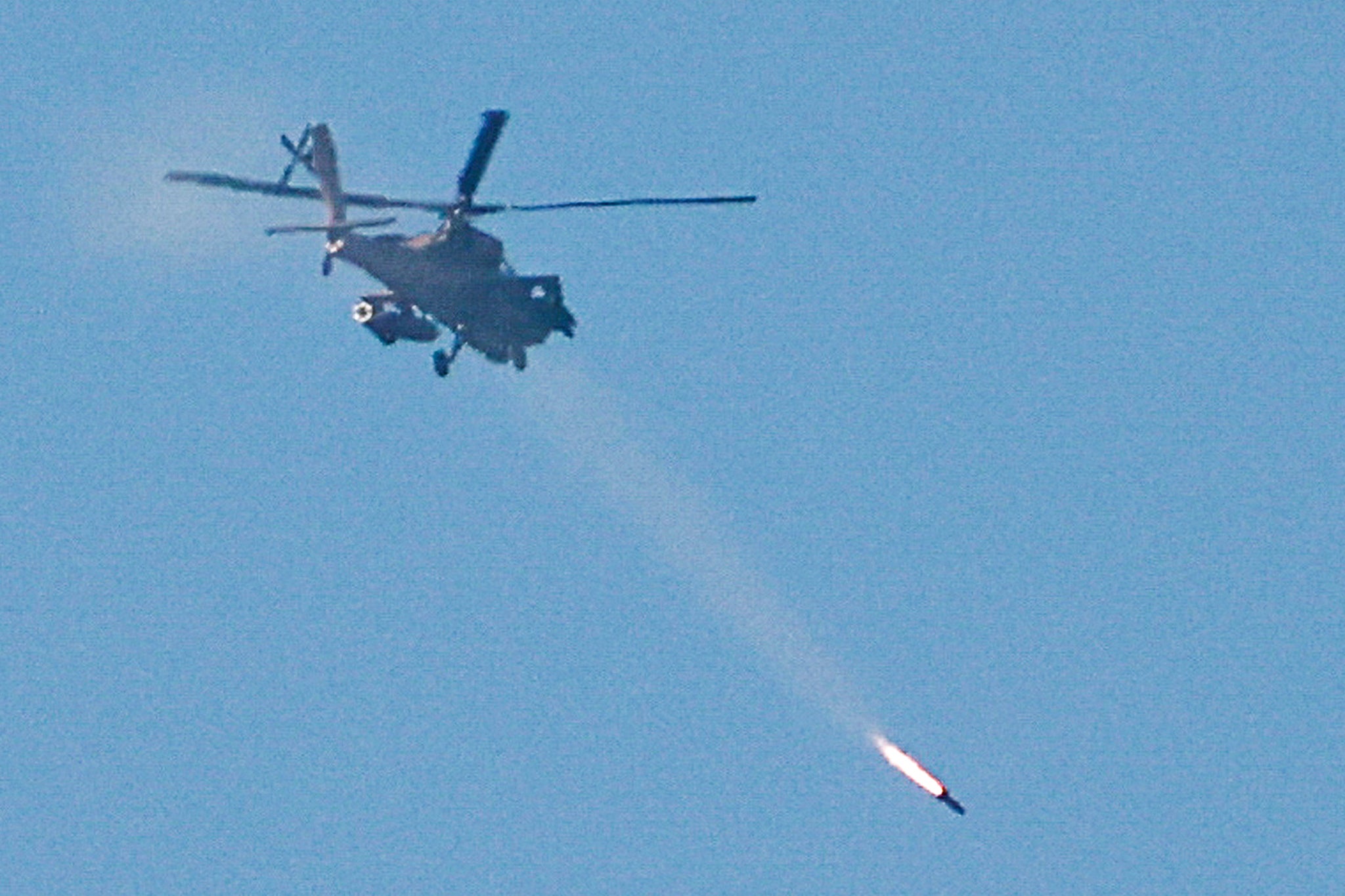 An Israeli Apache attack helicopter fires a missile towards southern Lebanon, amid ongoing hostilities between Hezbollah and Israel, as seen from near Ein Ya'akov, northern Israel.