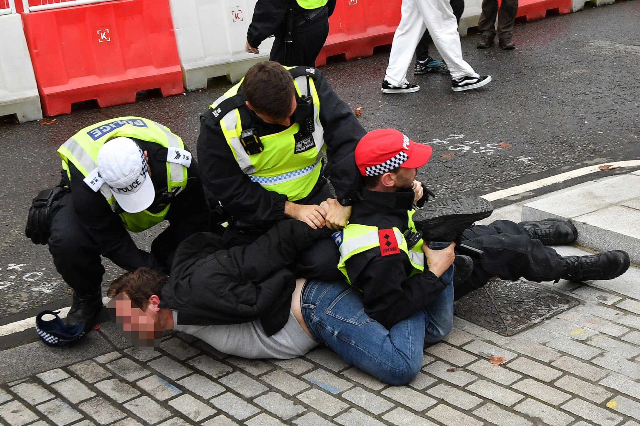 Police intervene as a protestor is held to the ground during the counter protest, Stand up to Racism in London