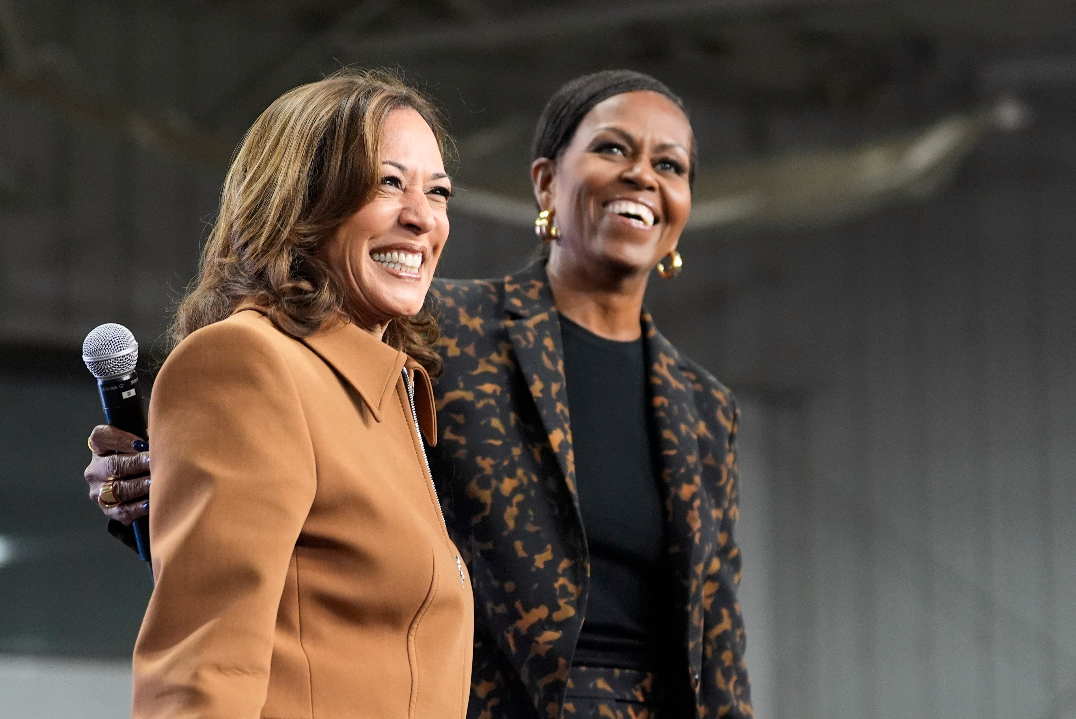 Former first lady Michelle Obama, right, and Democratic presidential nominee Vice President Kamala Harris address the crowd in the overflow space of a campaign rally at the Wings Event Center in Kalamazoo, Michigan. The Obamas and the Clintons congratulated Doanld Trump and JD Vance on their Election Day victory