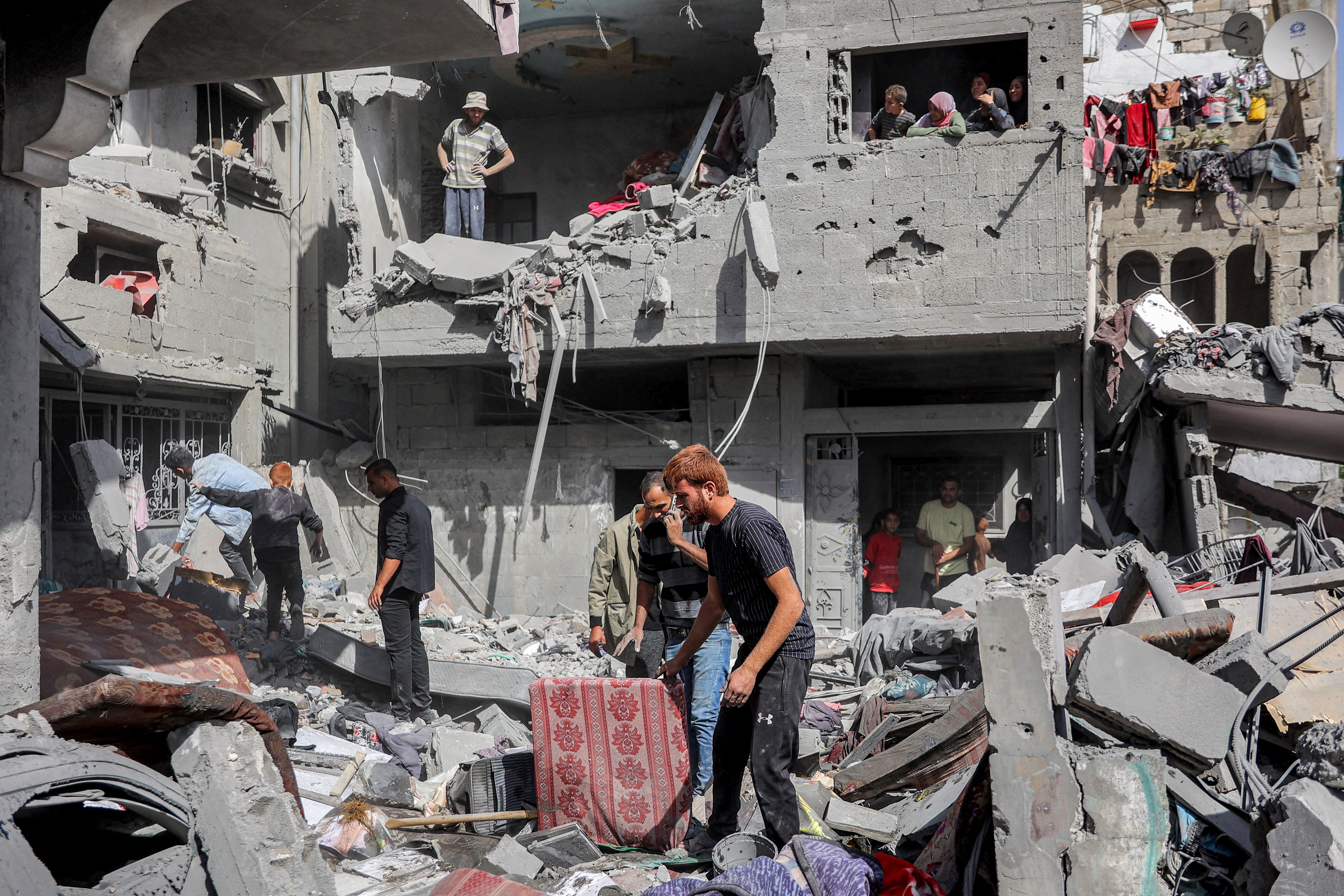 People search for survivors and victims through the rubble following Israeli bombardment in the north of Gaza City on 26 October 2024