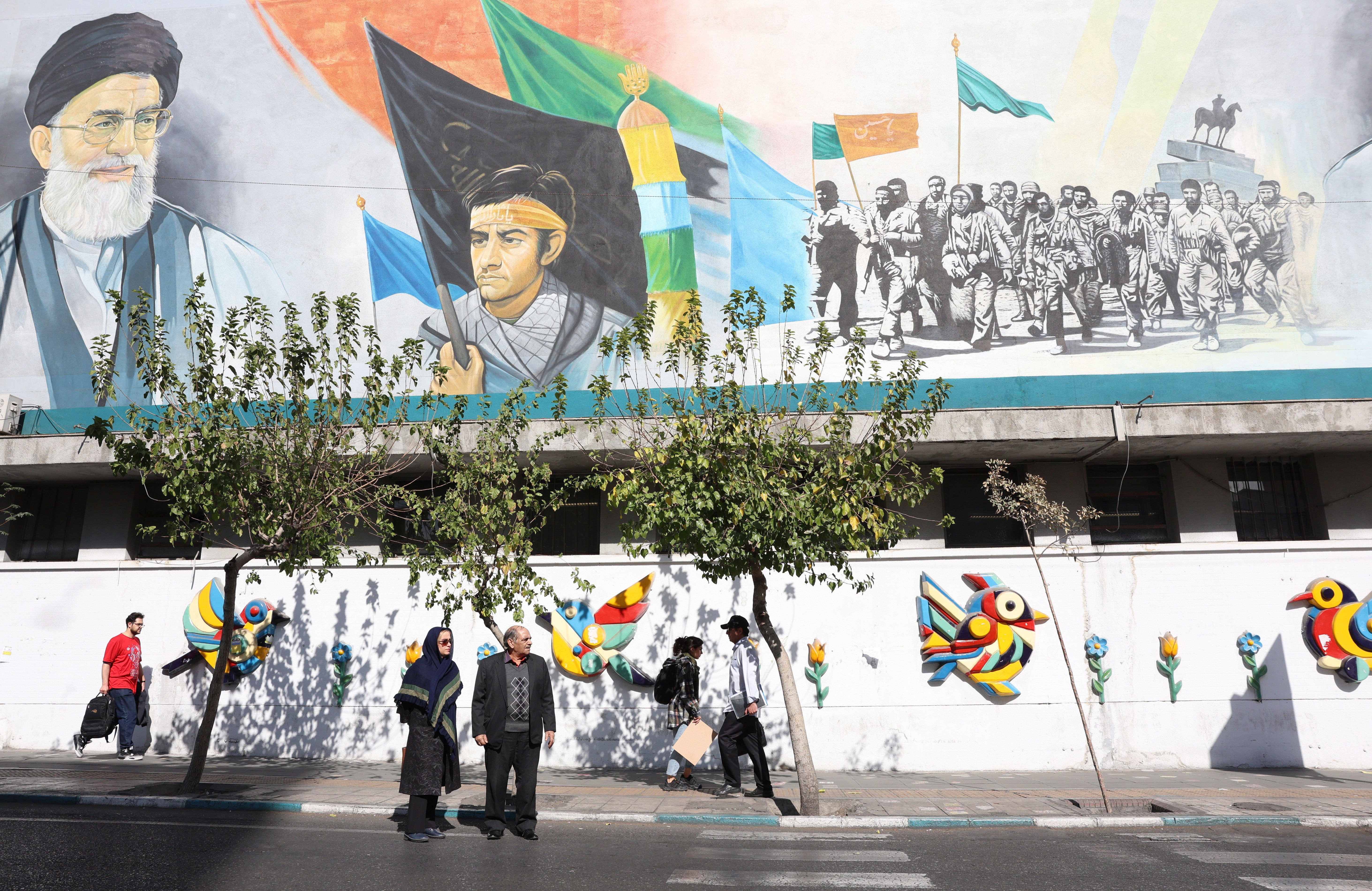 Iranians walks past a wall painting of Iranian Supreme Leader Ayatollah Ali Khamenei in Tehran, Iran, 26 October 2024