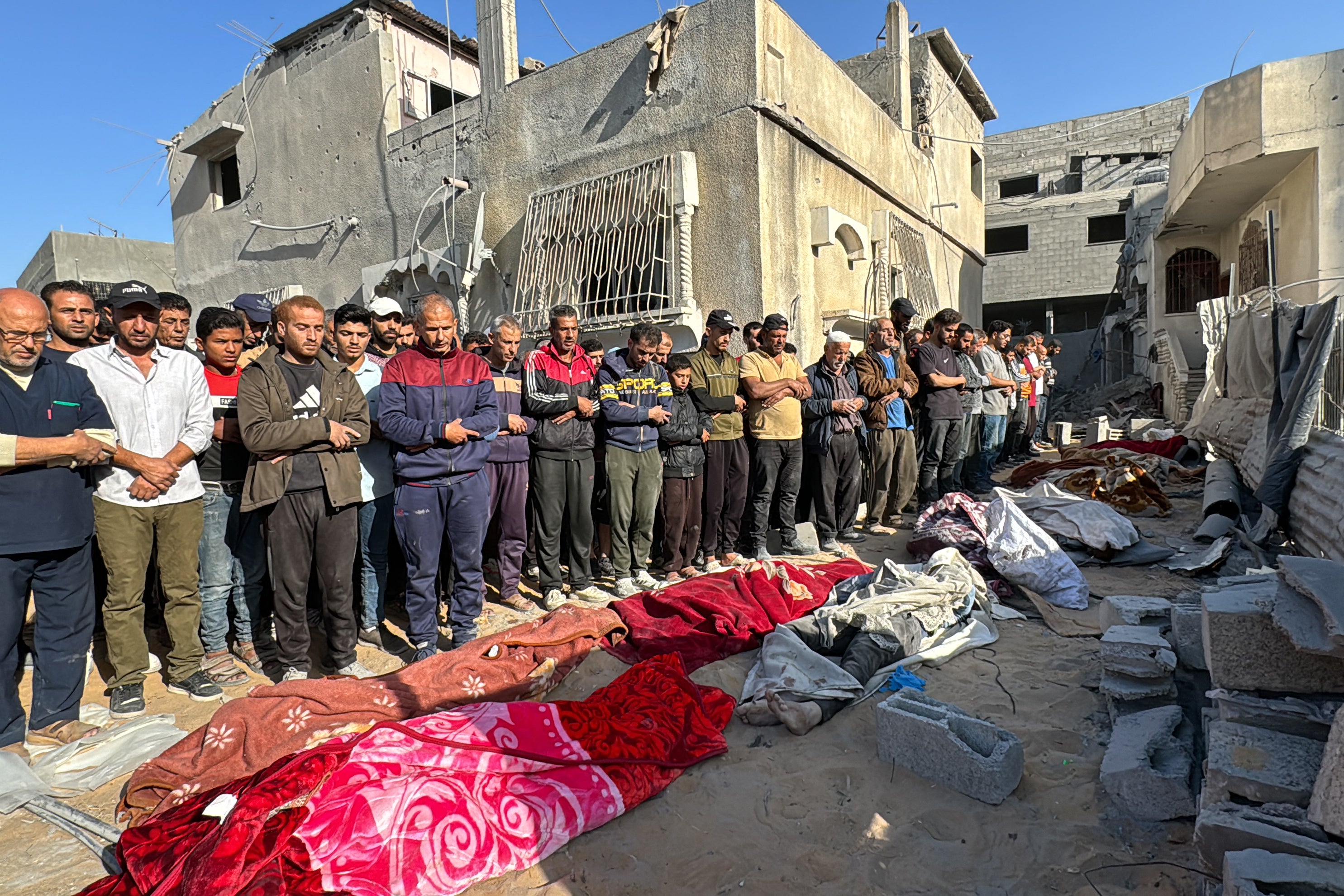 Palestinians pray over bodies of relatives, killed in an overnight Israeli airstrike, in Beit Lahia the northern Gaza Strip on October 27