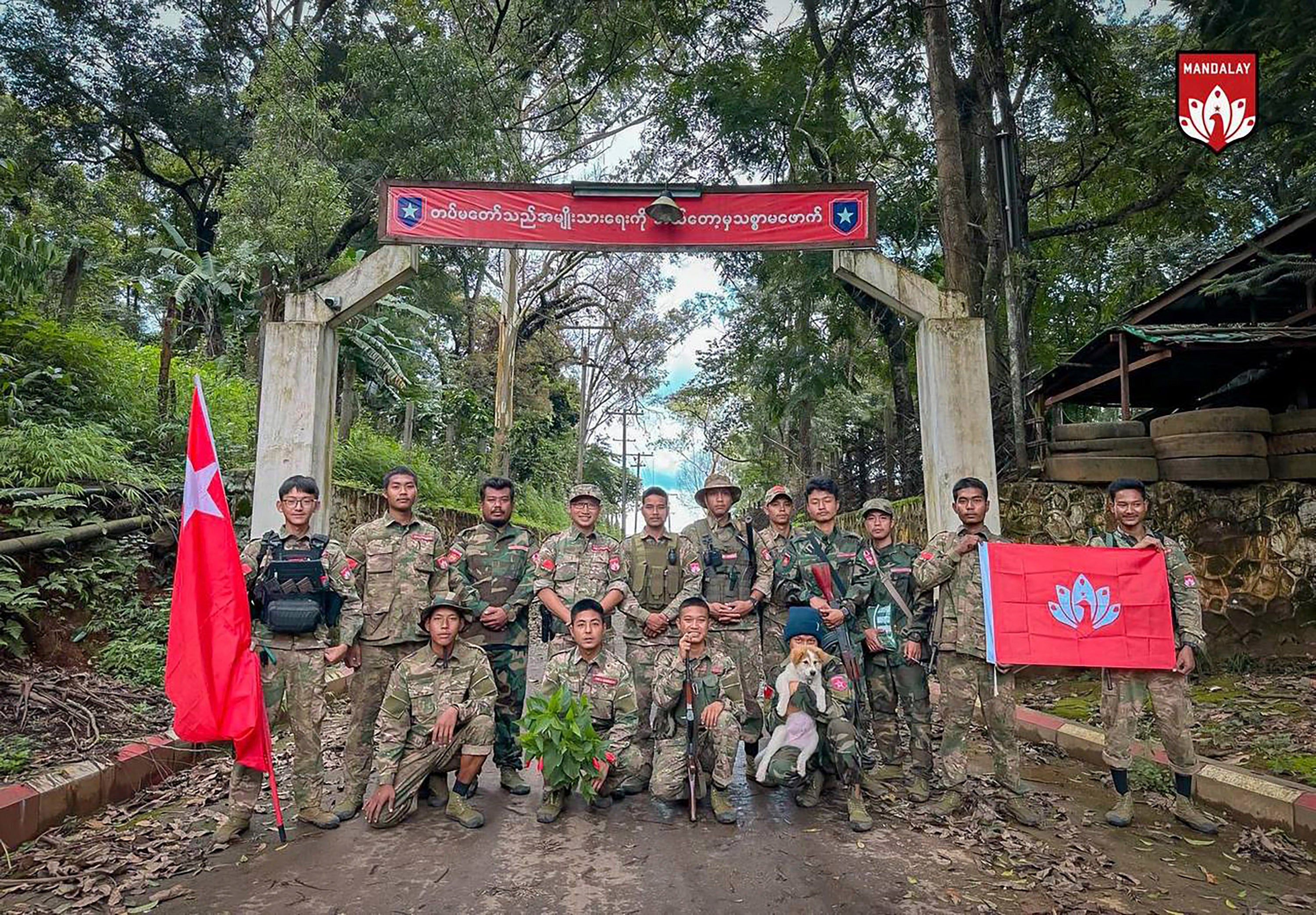 Members of the rebel Mandalay People’s Defence Force at the gate of a captured army facility in Mogok township in July 2024