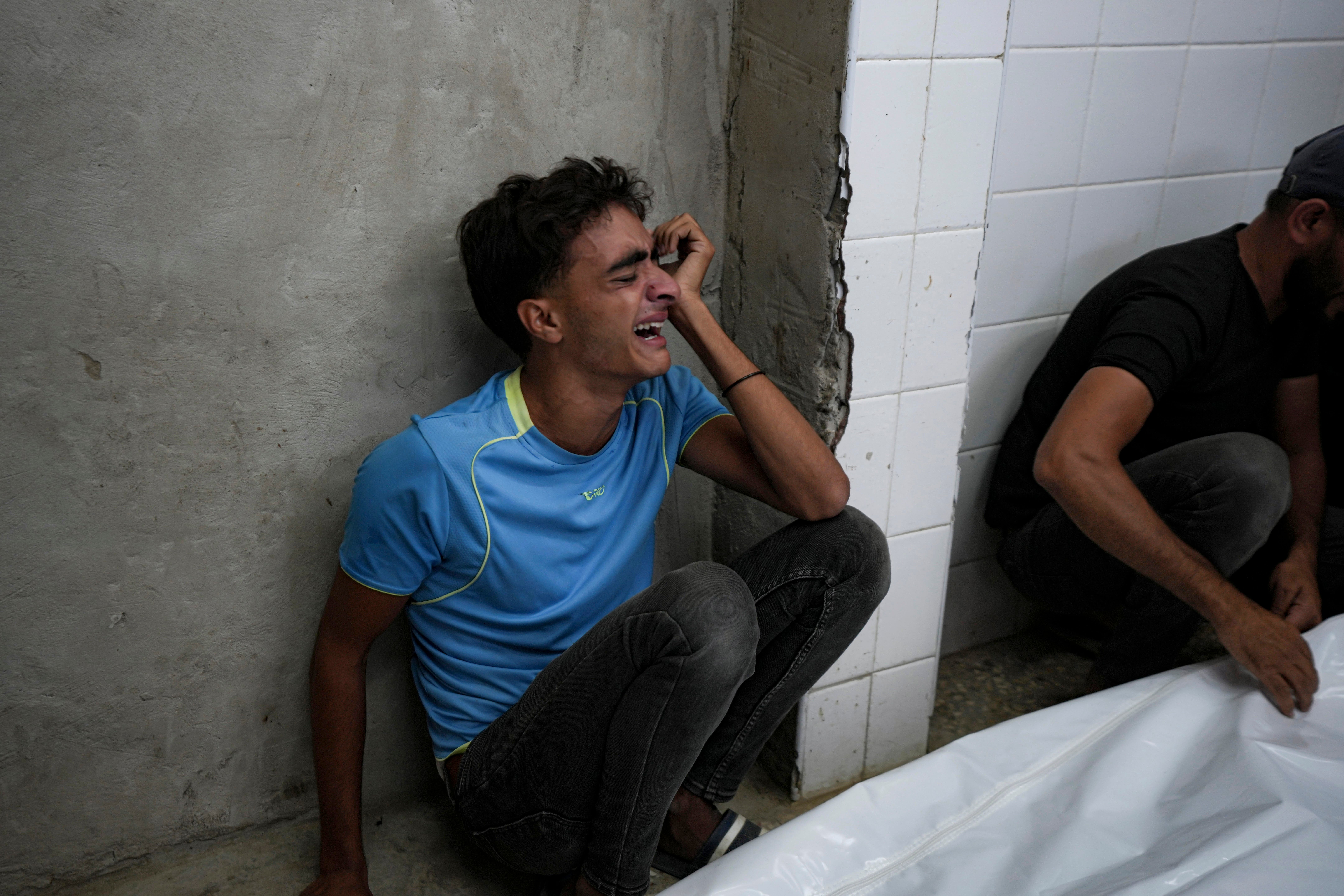 A young Palestinian mourns his relatives killed in the Israeli bombardment of the Gaza Strip at a hospital in Deir el-Balah (Abdel Kareem Hana/AP)