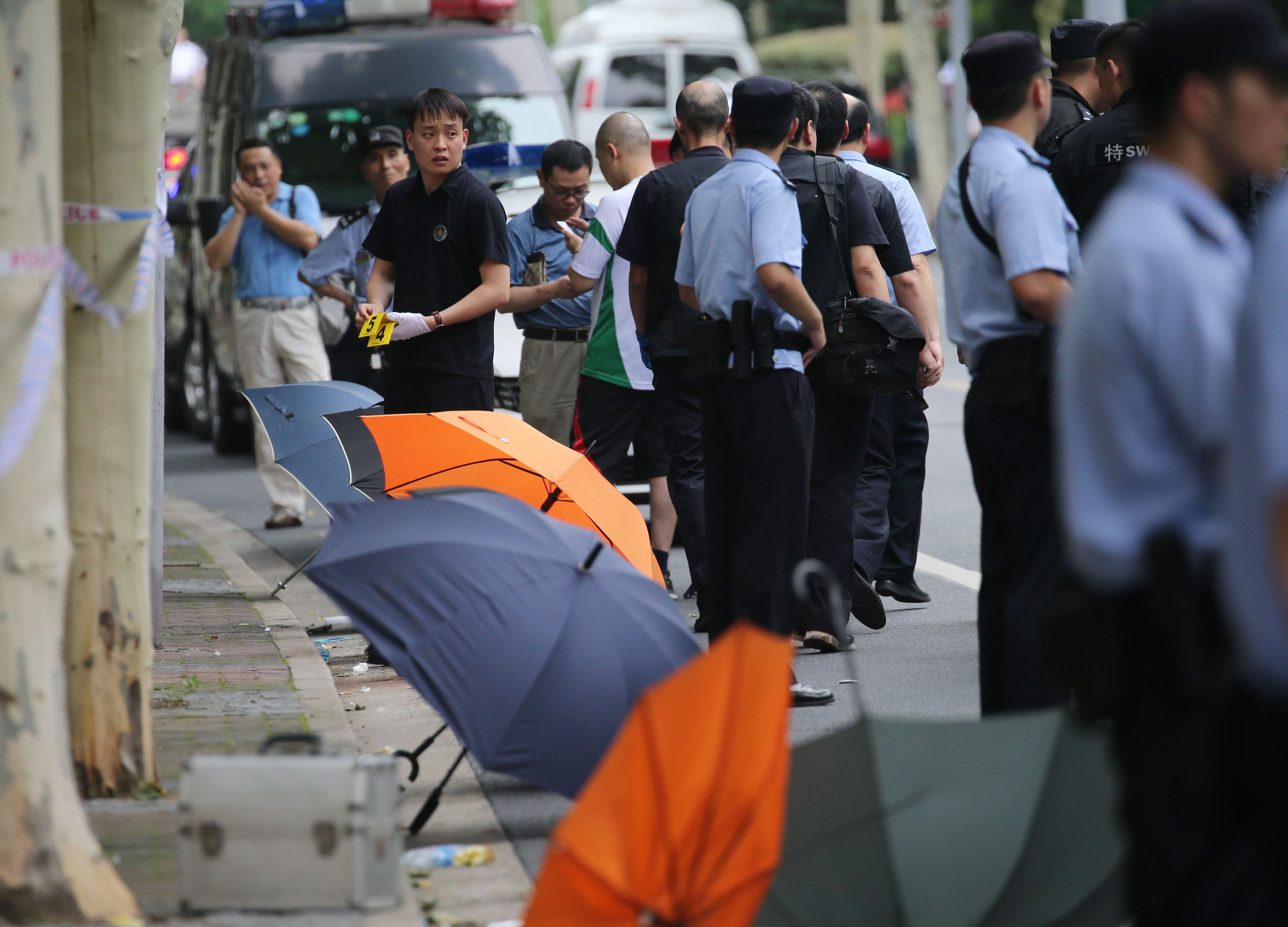 Police officers stand guard near the scene where two boys were killed outside an elementary school in Shanghai on 28 June 2018