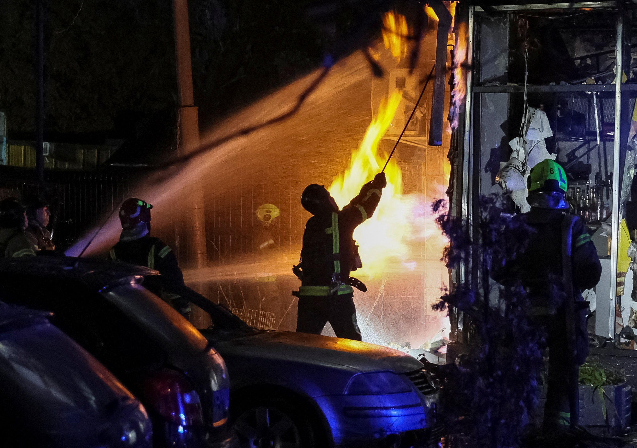 Firefighters work at a site of an apartment building hit by a Russian drone strike, amid Russia’s attack on Ukraine, in Kyiv