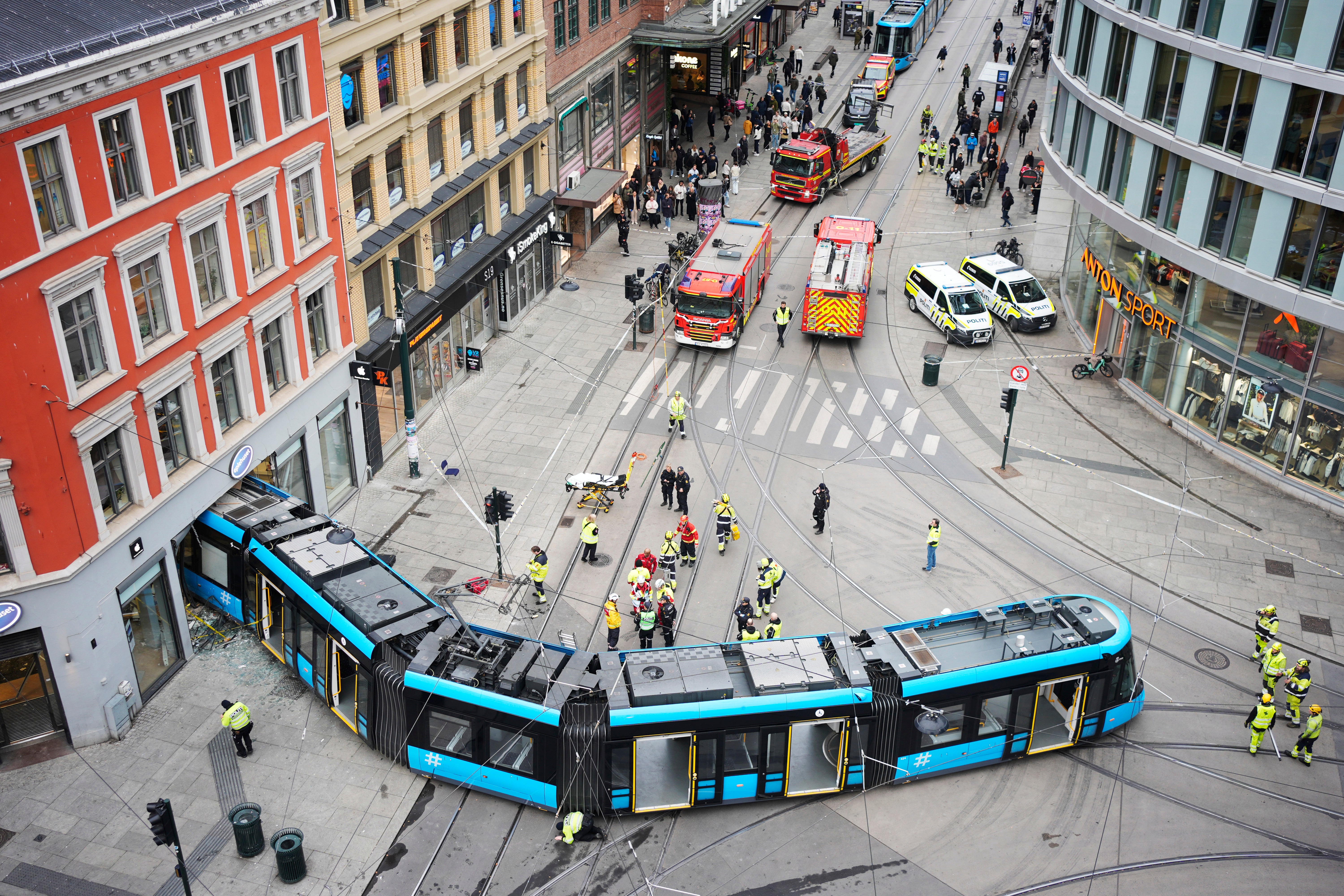 Emergency workers at the scene of a derailed tram that crashed into a building in downtown Oslo, Norway