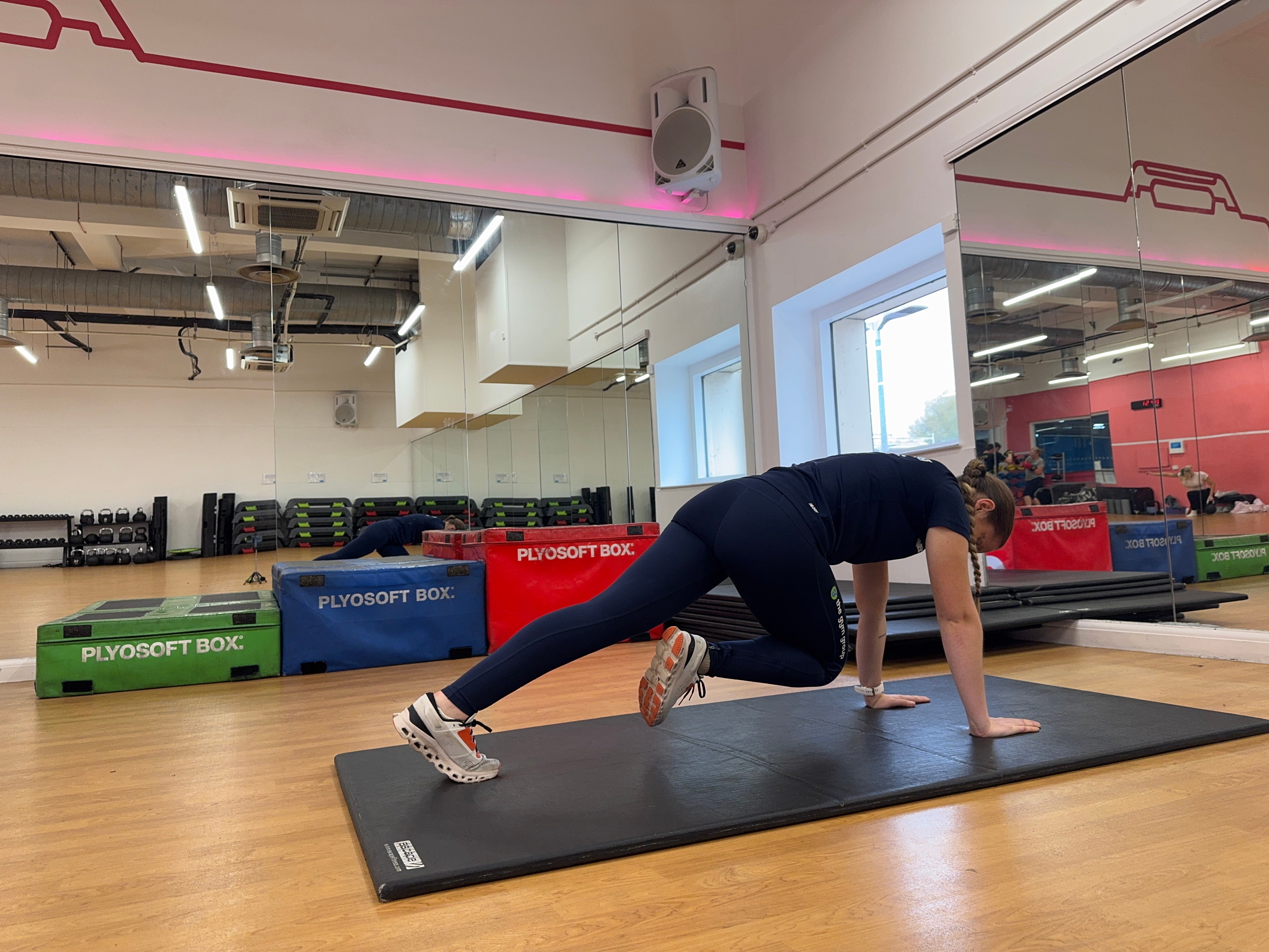 Trainer Sasha Bridgen demonstrating a cross-body mountain climber