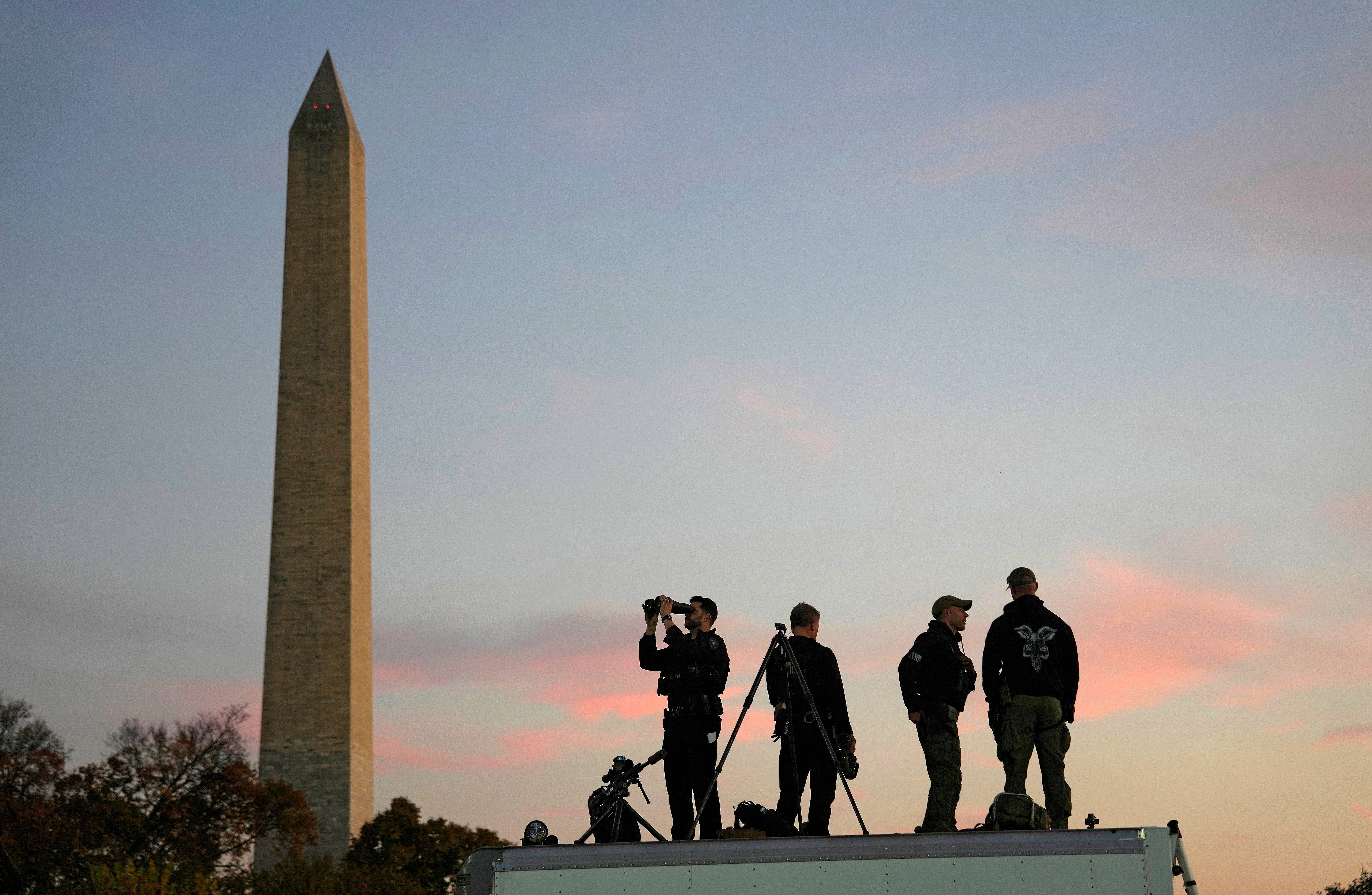 Secret Service agents stand guard near the Washington Monument before Harris took the stage