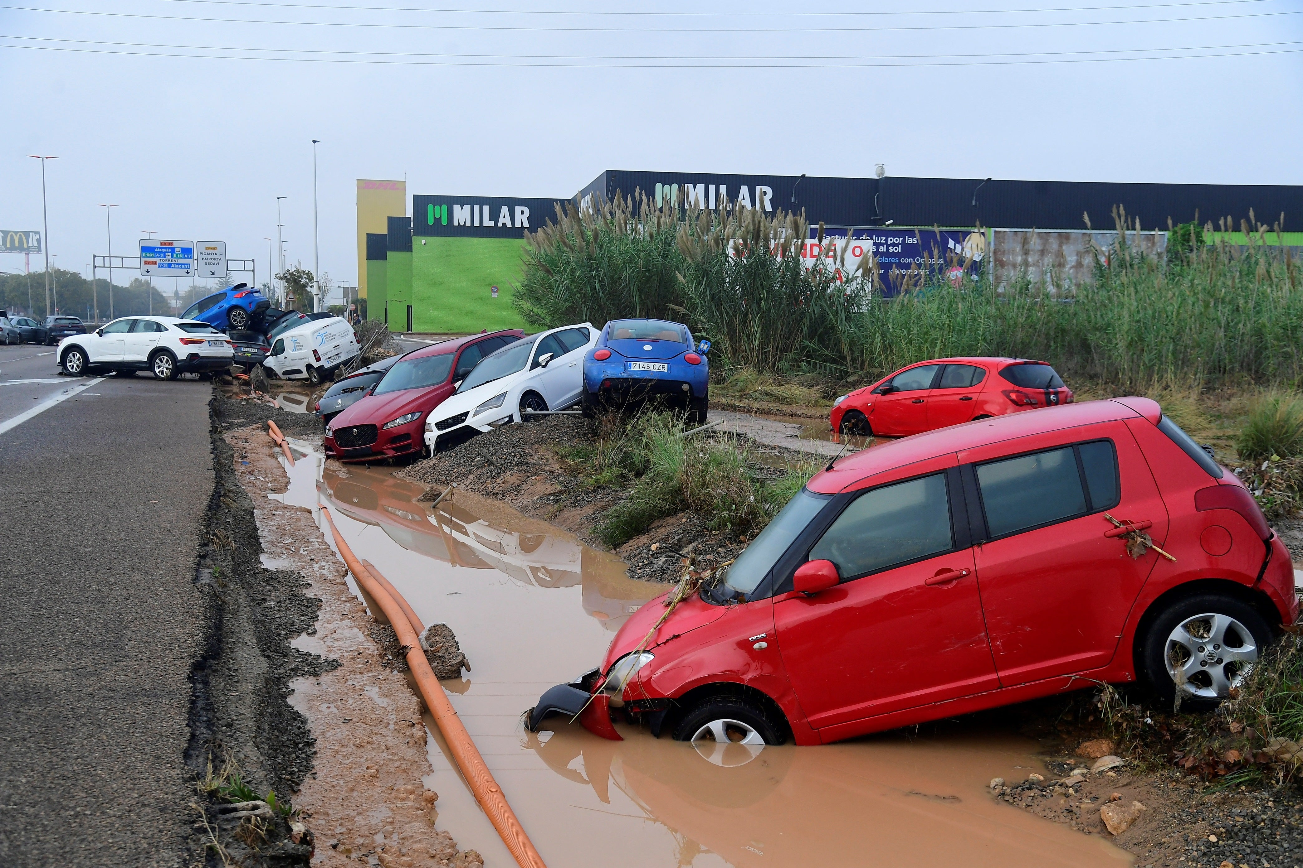 Cars washed on to the side of the road by flooding in Picuana