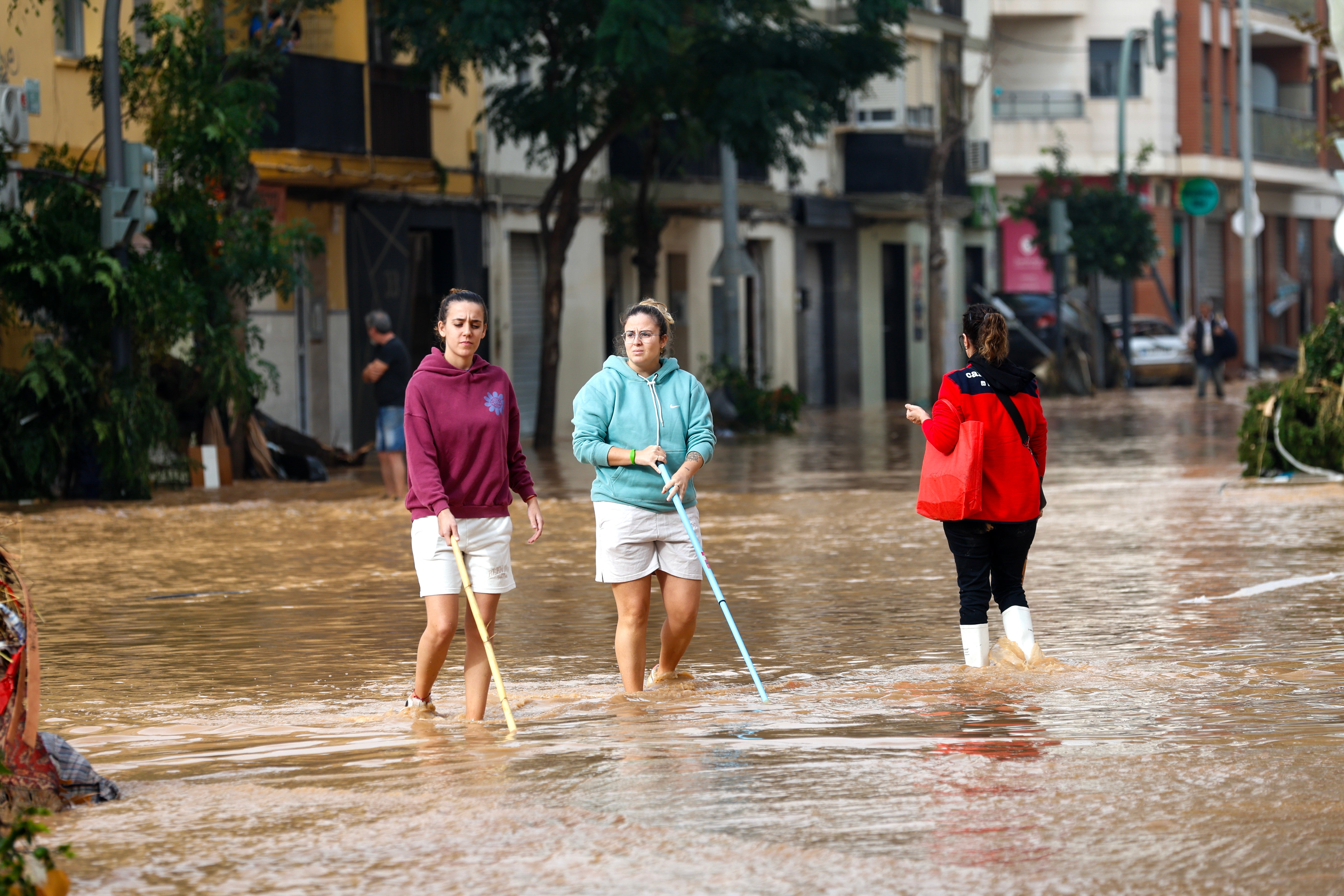 Residents cross a flooded street in Sedavi, in the province of Valencia, eastern Spain