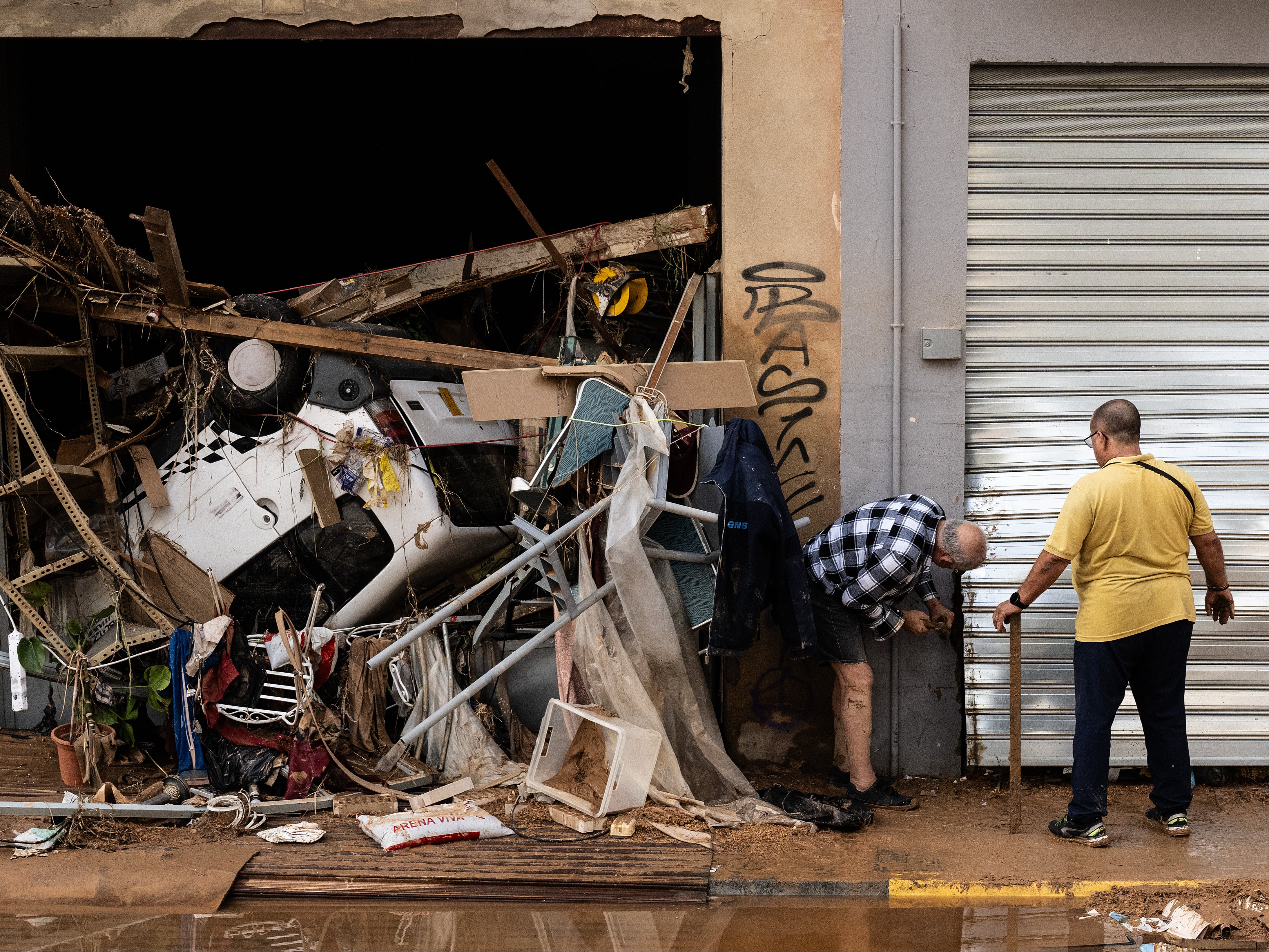 People check the damage to their shop in Valencia