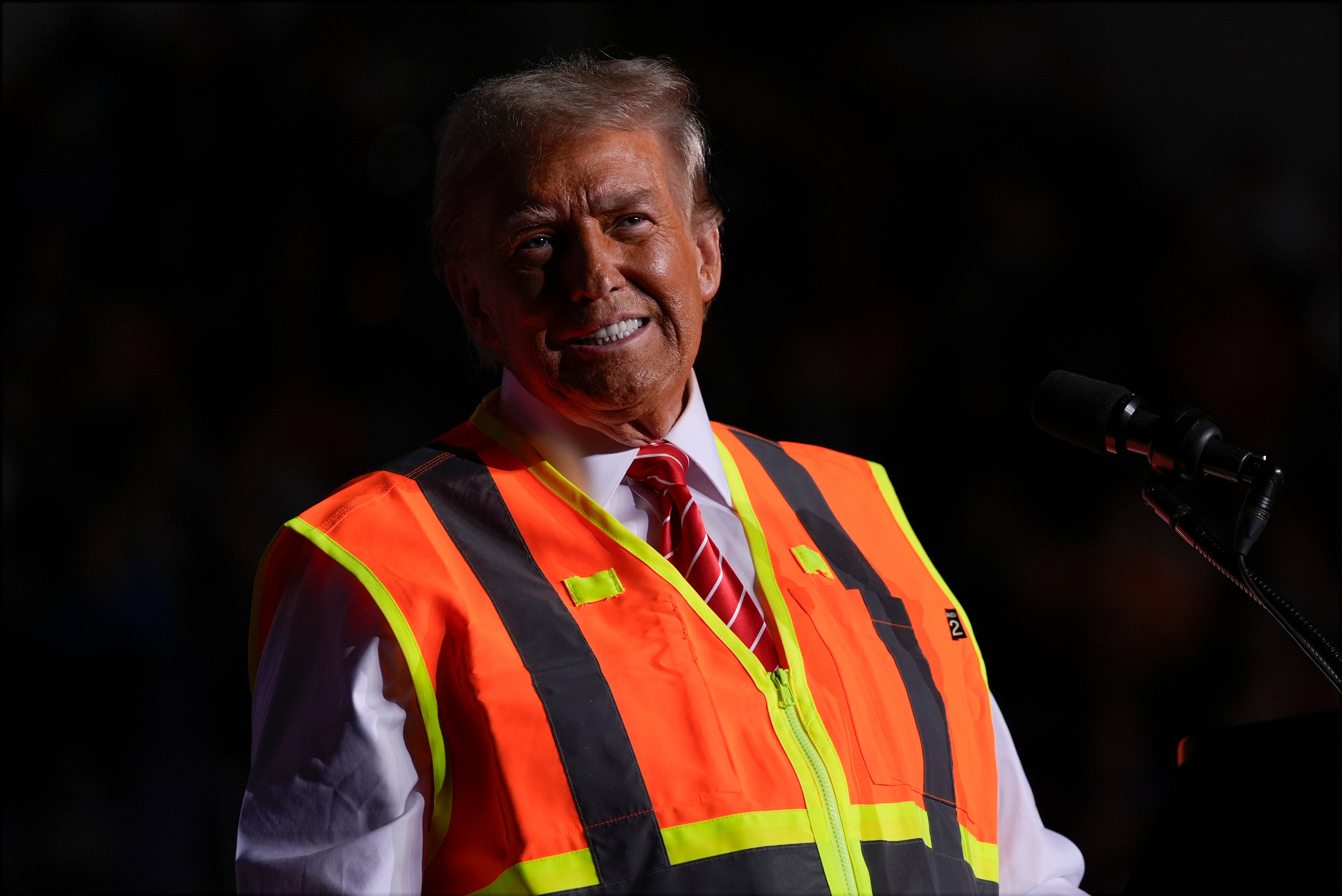 Donald Trump speaks during a campaign rally in Green Bay, Wisconsin, still wearing his bright orange safety vest from an earlier stunt involving a garbage truck