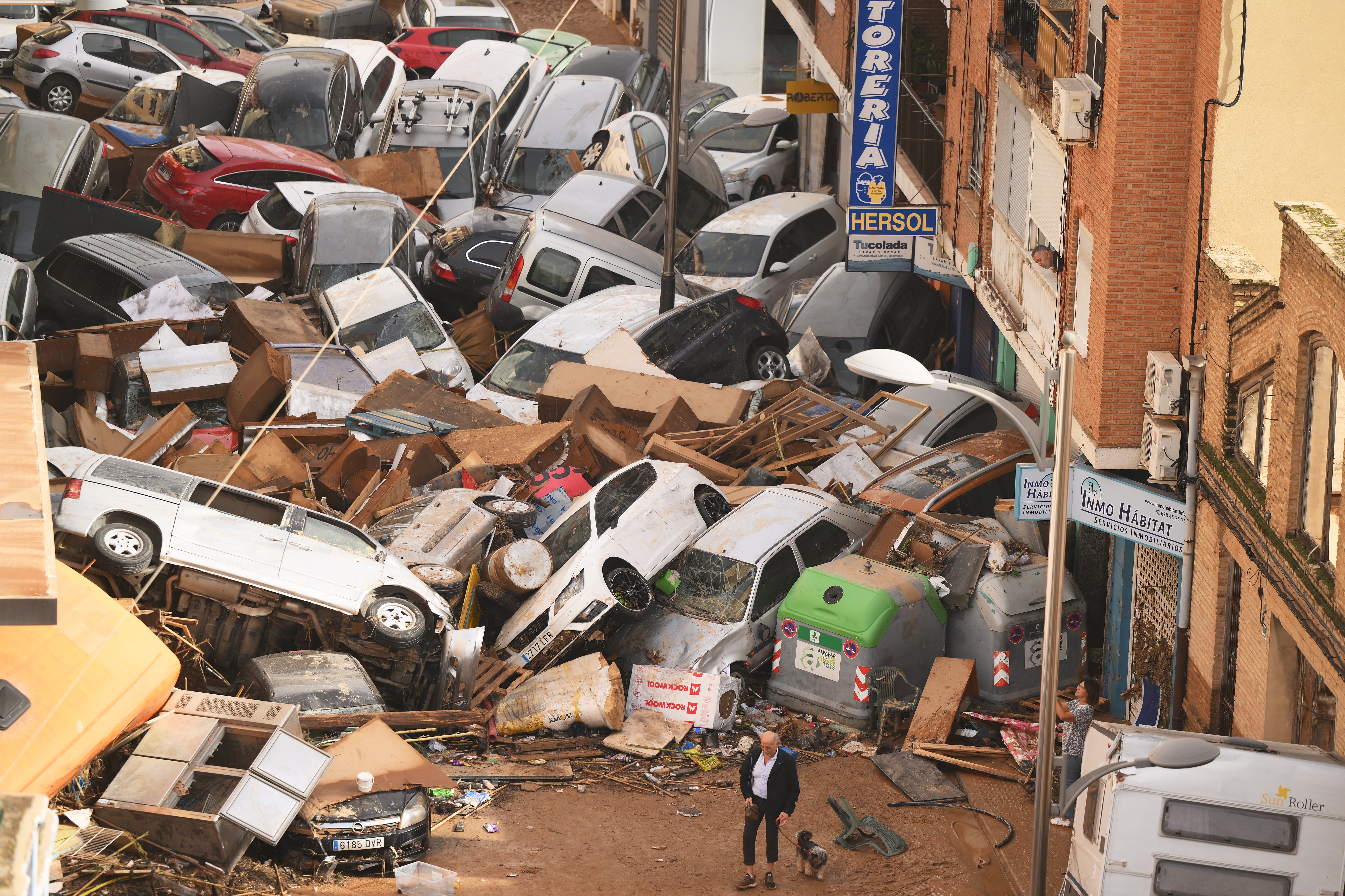 Cars are piled in the street with other debris after flash floods hit the region