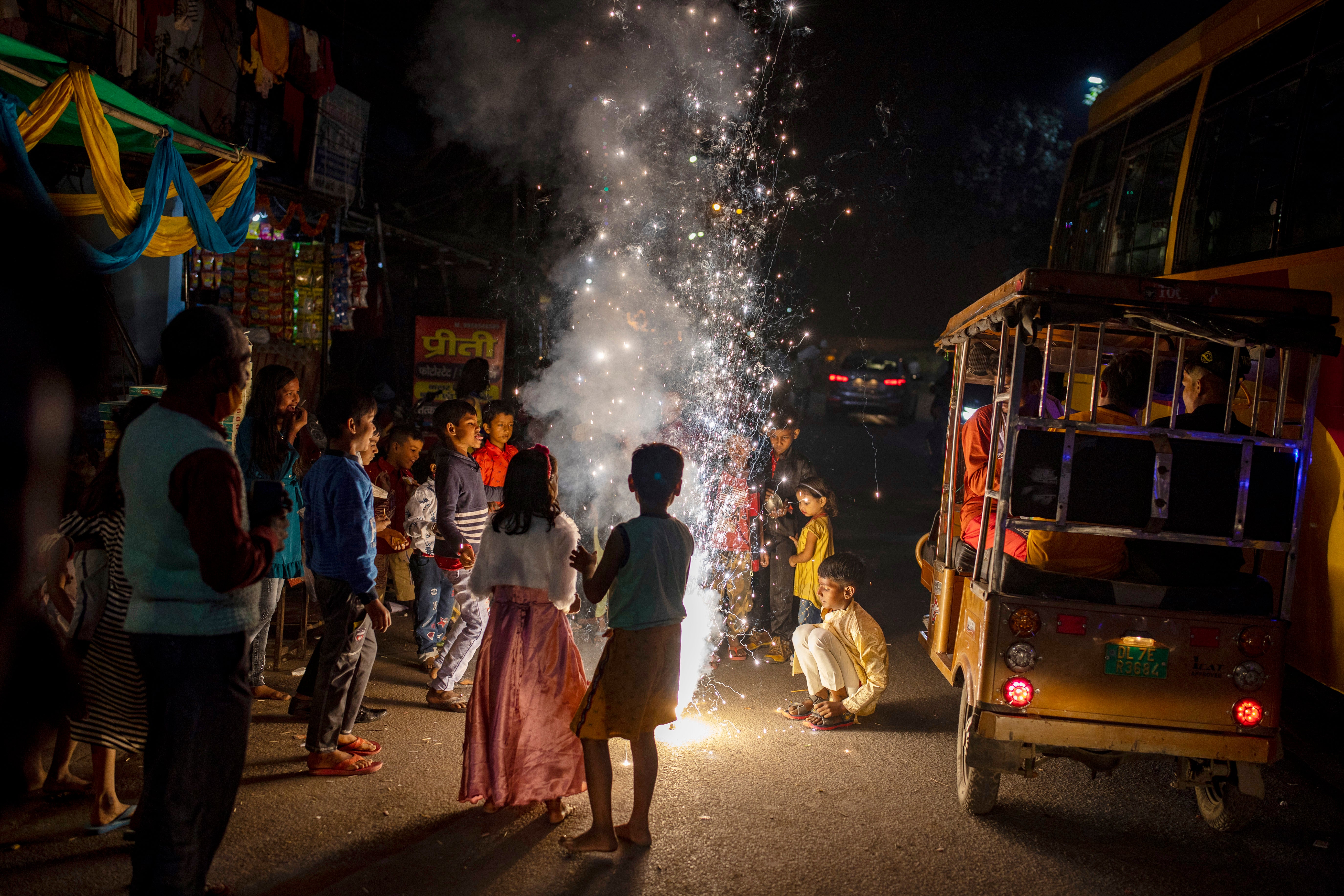 Children play with firecrackers during Diwali celebrations in New Delhi, India