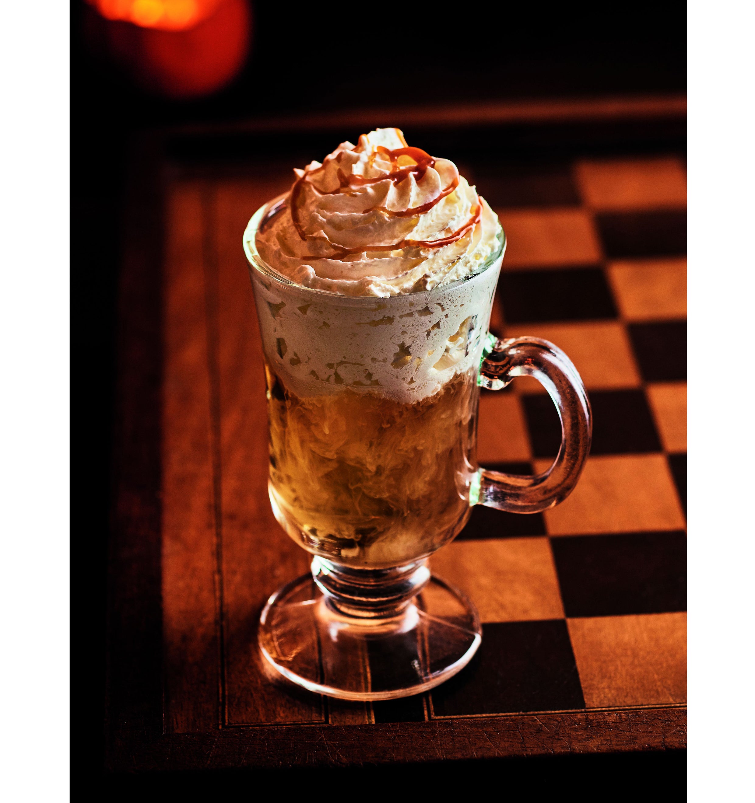 A luxurious, creamy cocktail with vodka, maple syrup, and lemon verbena tea, topped with a swirl of caramel for a sweet winter treat