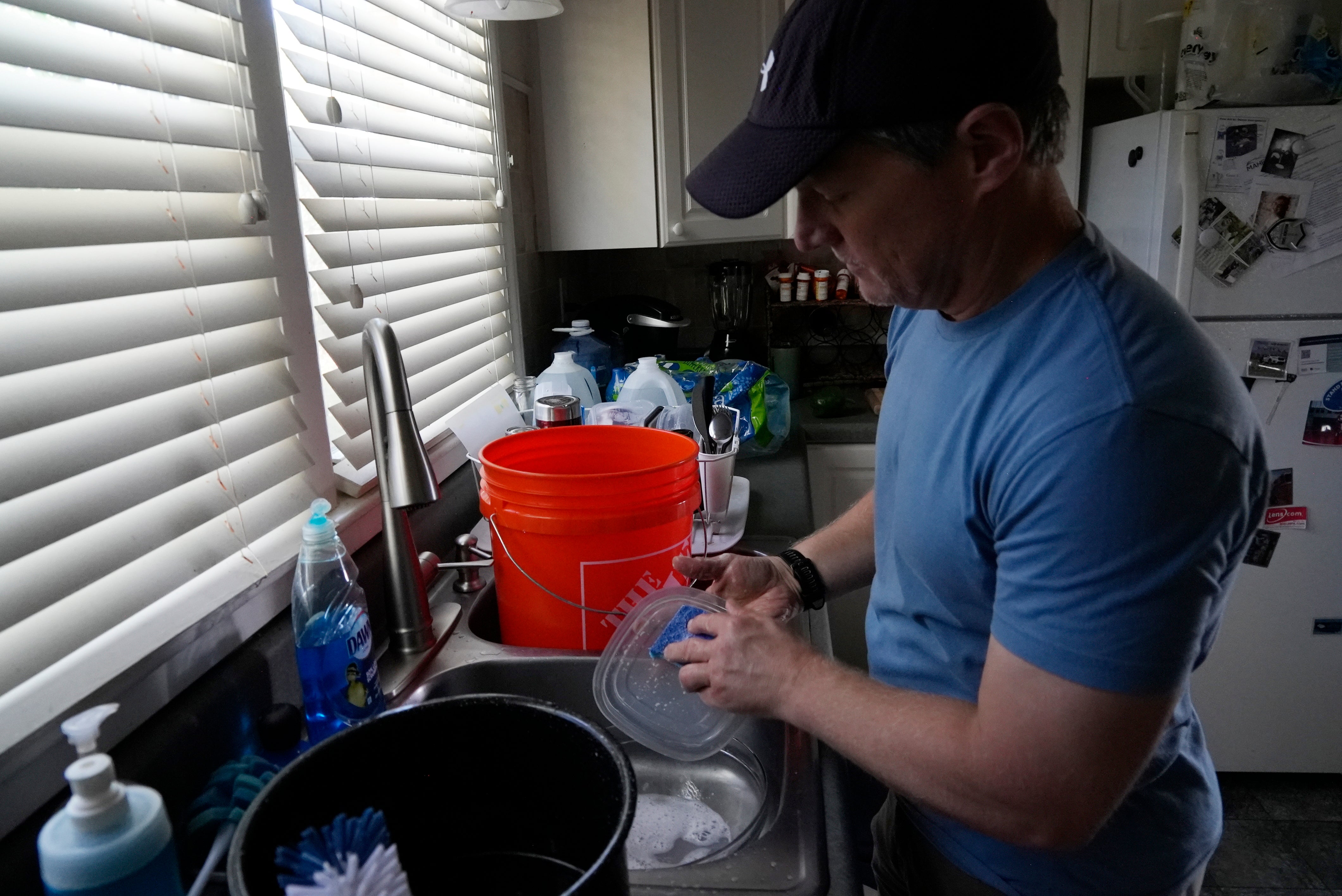 Travis Edwards captures water while cleaning dishes last month in Asheville, North Carolina. Asheville residents still don’t have clean drinking water nearly two months after Hurricane Helene struck the southeastern state.