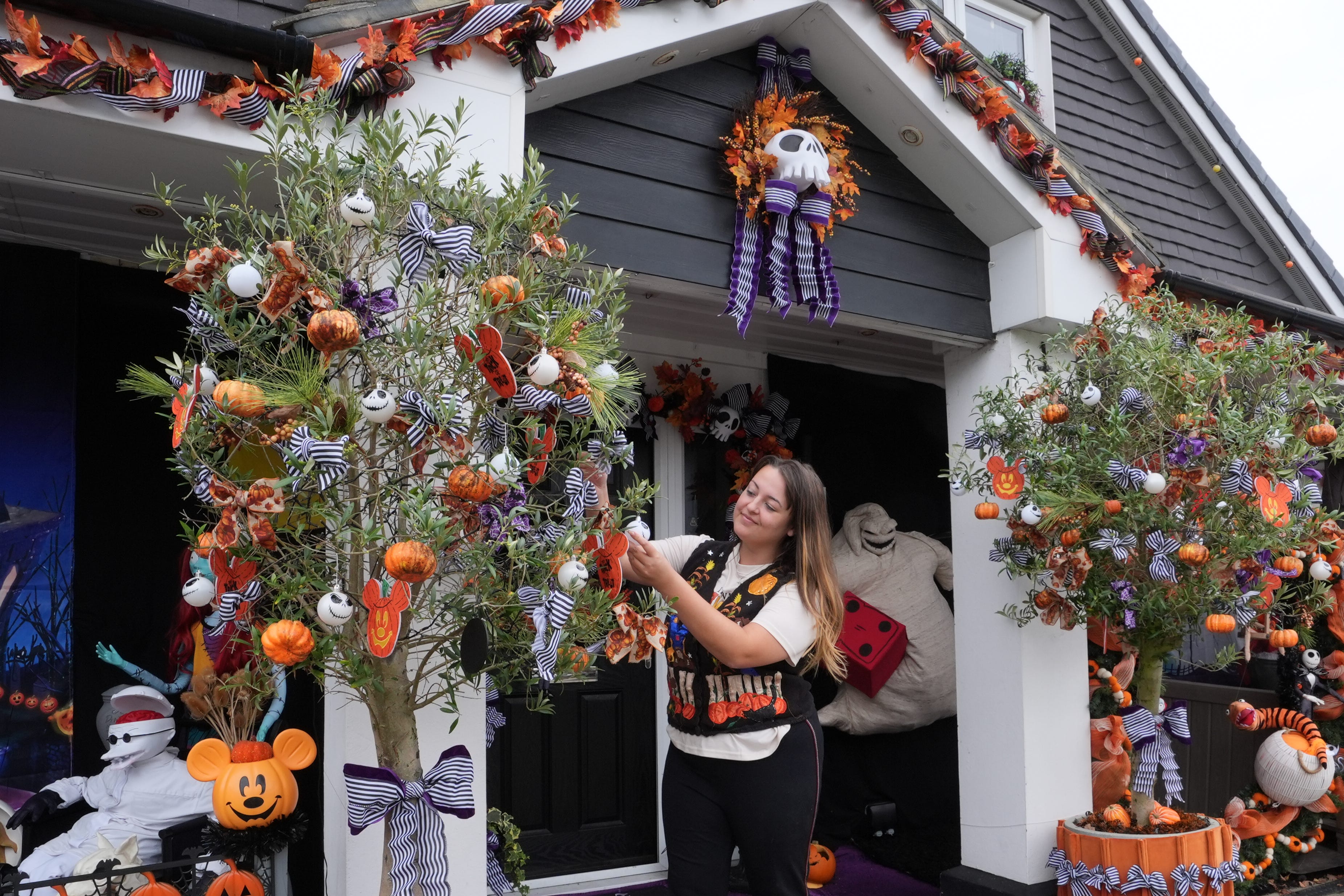 Lavinia Hedges puts the finishing touches to a Nightmare Before Christmas themed Halloween display (Gareth Fuller/PA)