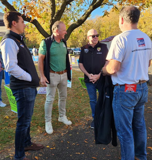 Larry Hogan speaks with supporters outside of a polling place in Odenton, Maryland, a suburb where he is hoping to turn out moderate Democrats and independents as well as his GOP base.