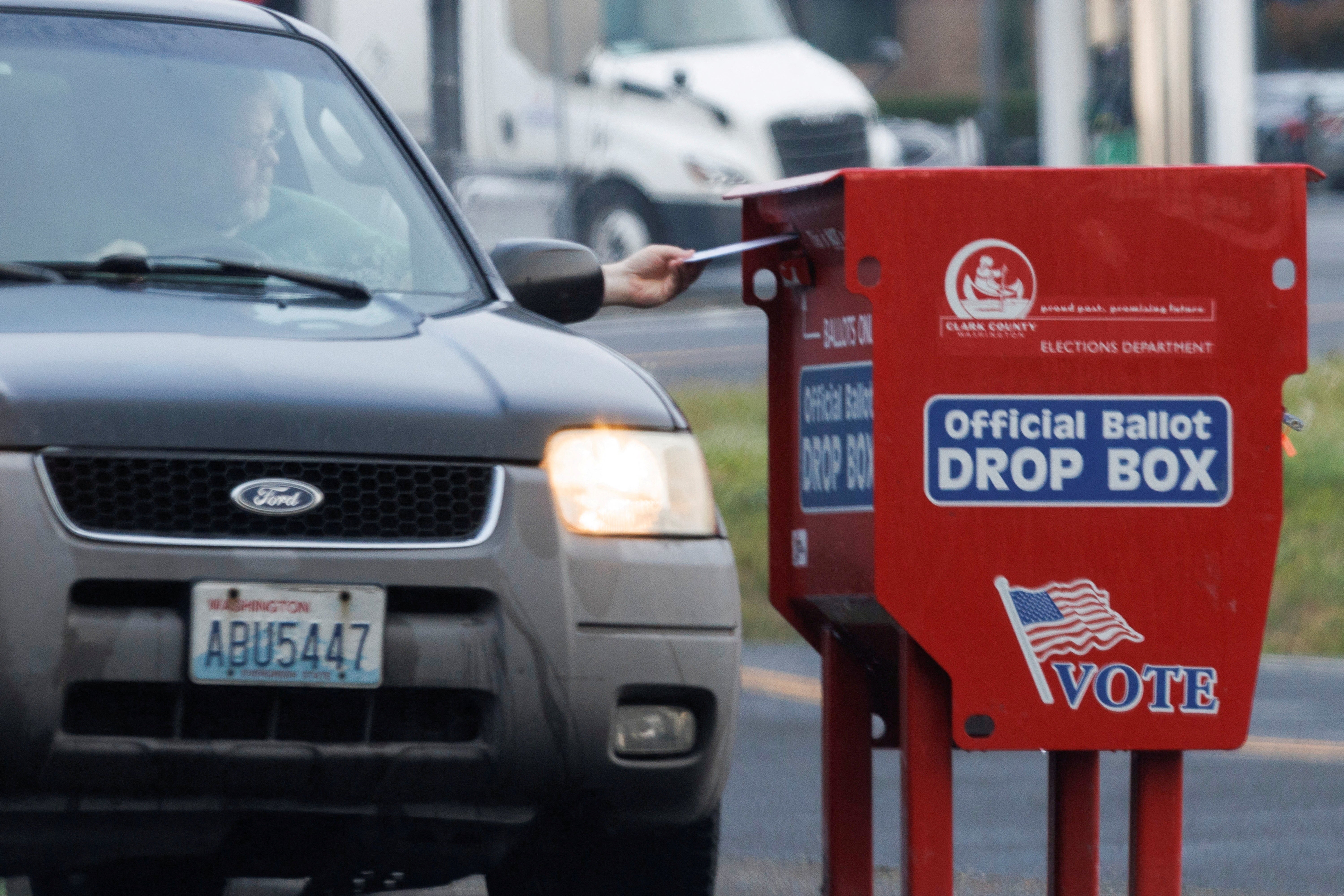 A voter drops a ballot into a freshly replaced ballot box in Vancouver, Washington, on Tuesday. Voter turnout in Washington is reportedly lagging this year.