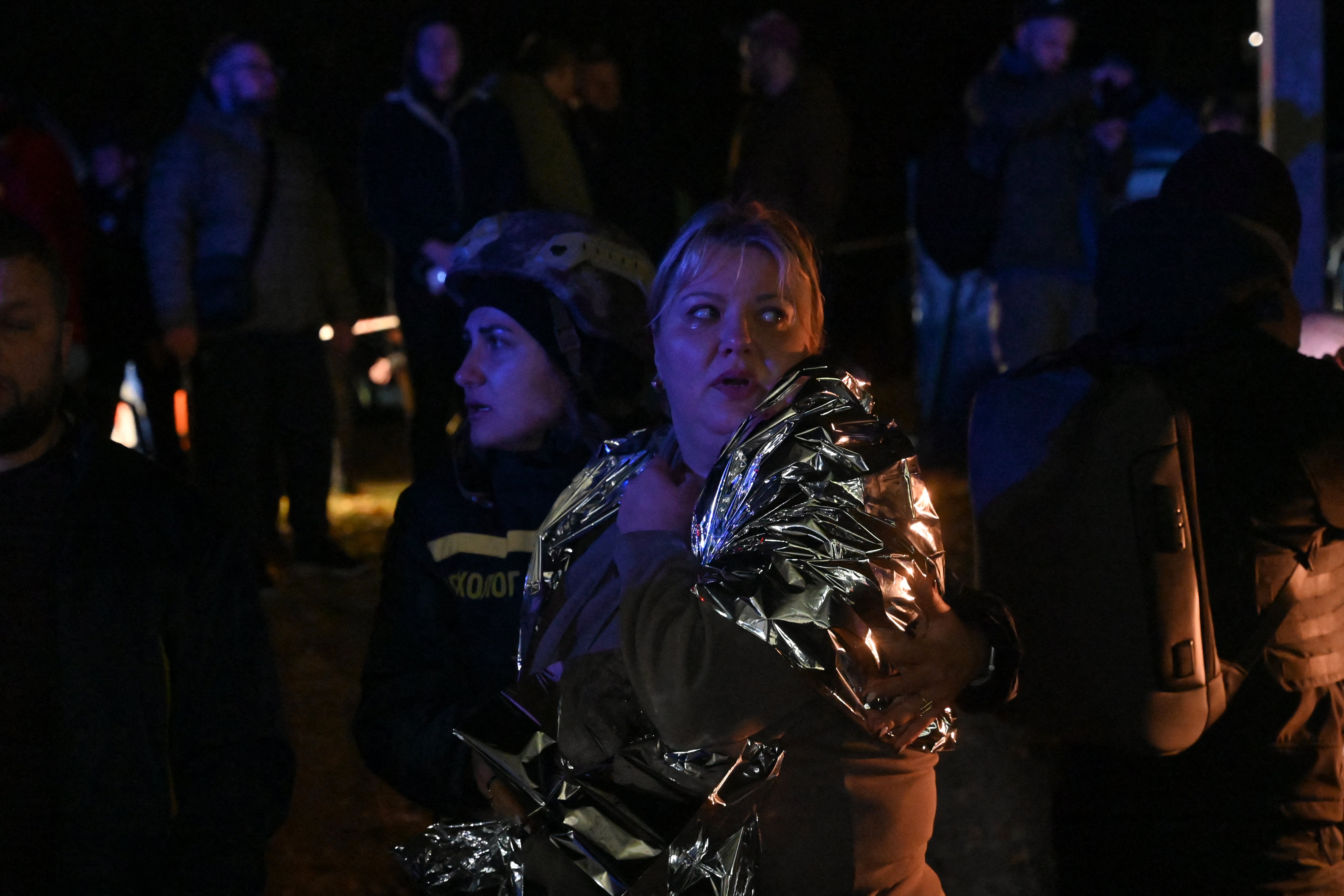 A psychologist of the State Emergency Service of Ukraine helps an injured resident of an apartment building damaged after an airstrike in Kharkiv