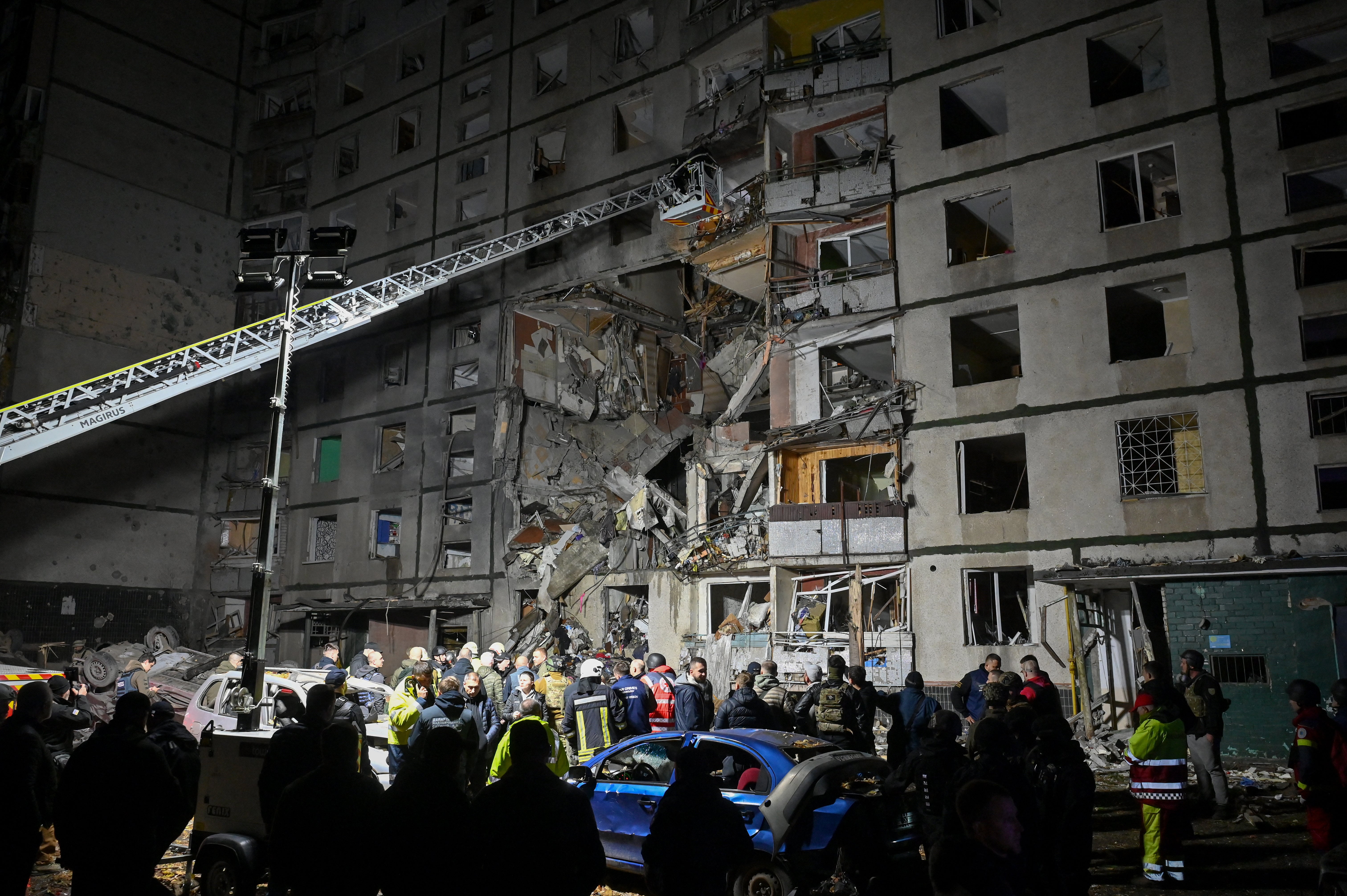 Police officers and State Emergency Service of Ukraine rescuers work at an apartment building damaged after an airstrike in Kharkiv