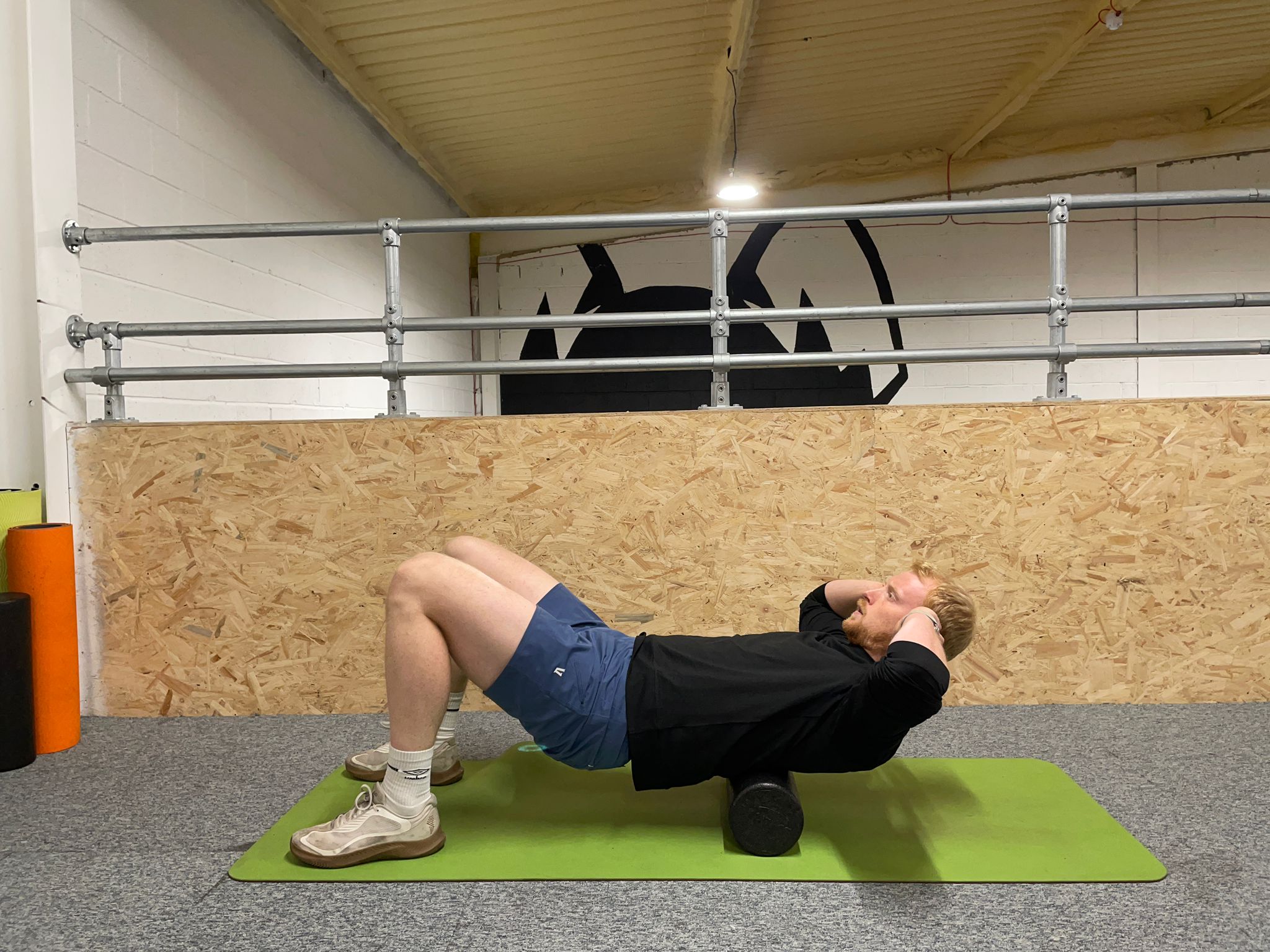 Demonstrating how to use a foam roller to soothe muscle soreness around the spine