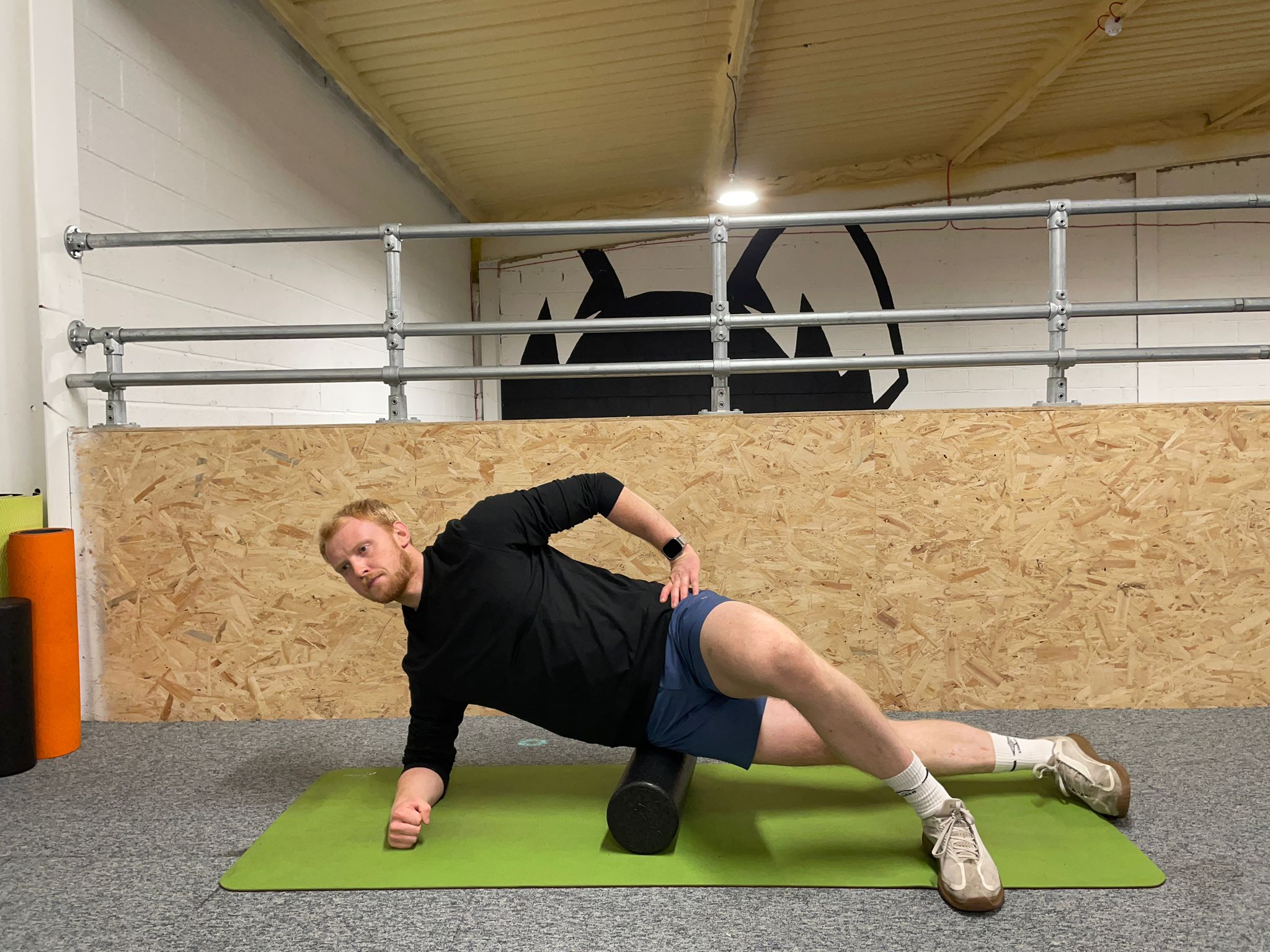 Demonstrating how to use a foam roller to soothe muscle soreness around the hips and lateral thigh