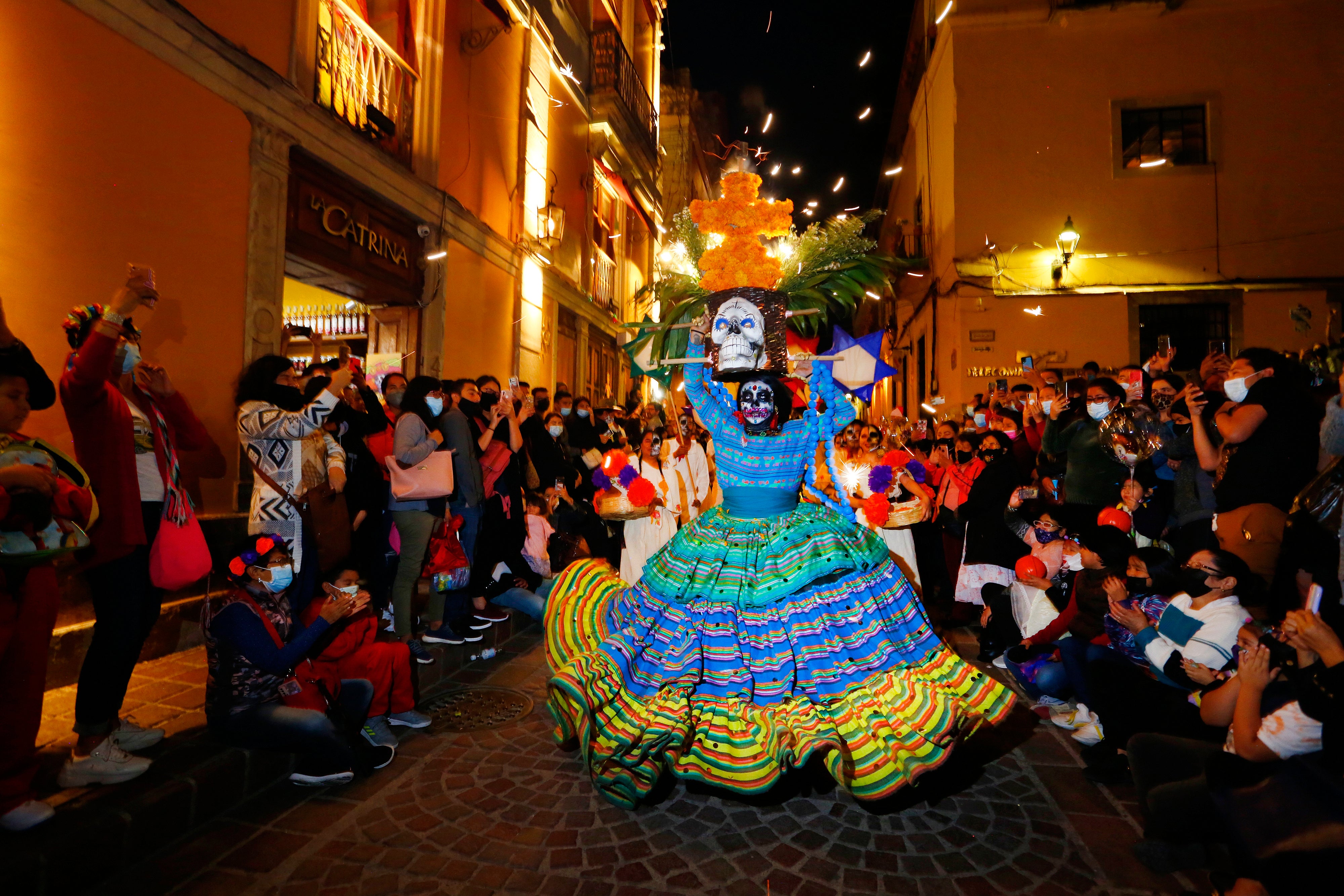 A woman dressed as a catrina dances during the parade of the Day Of The Dead Festival in Guanajuato in Mexico on November 1, 2021