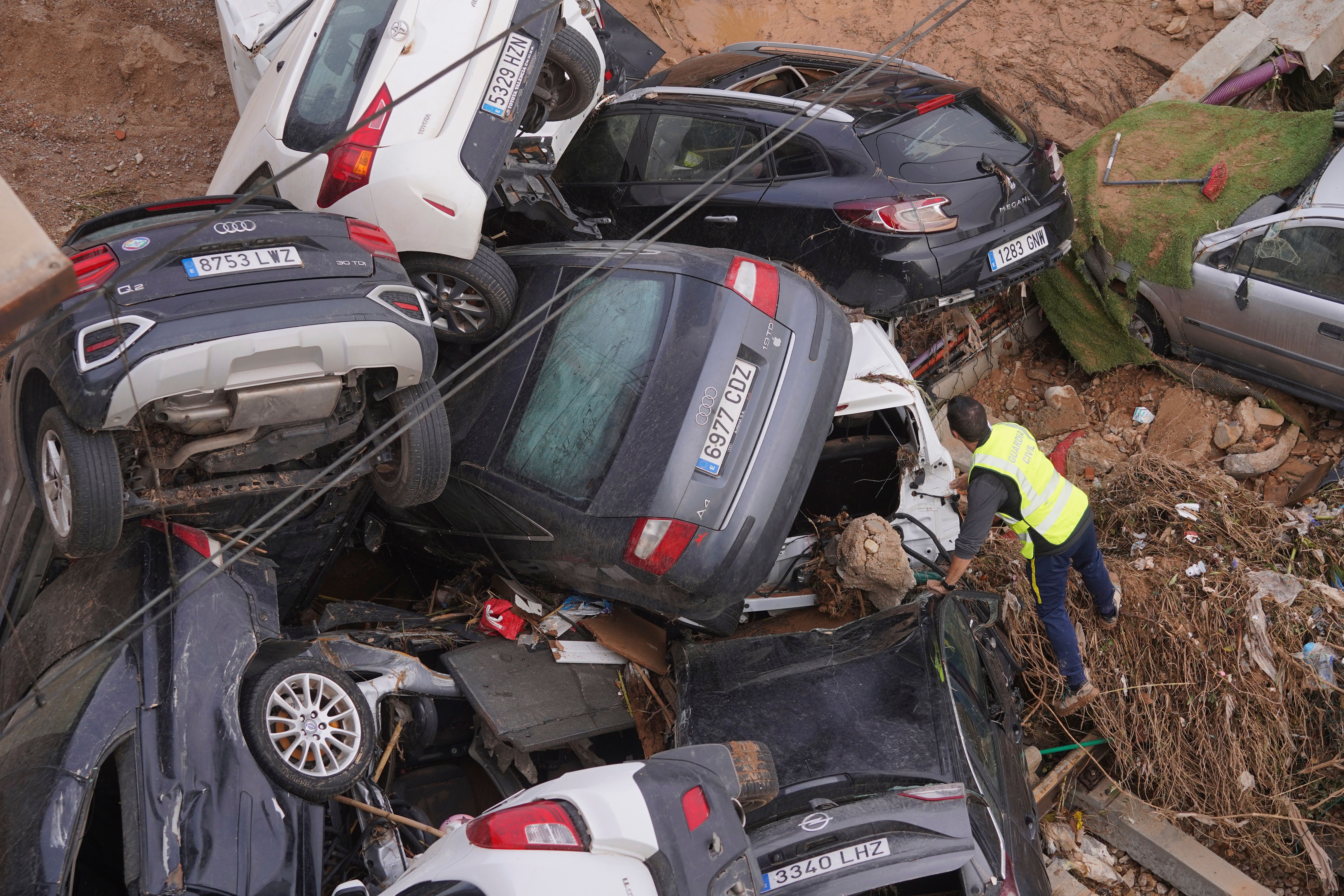 A civil guard searches for survivors in cars piled up on the outskirts of Valencia in Spain (AP Photo/Alberto Saiz)