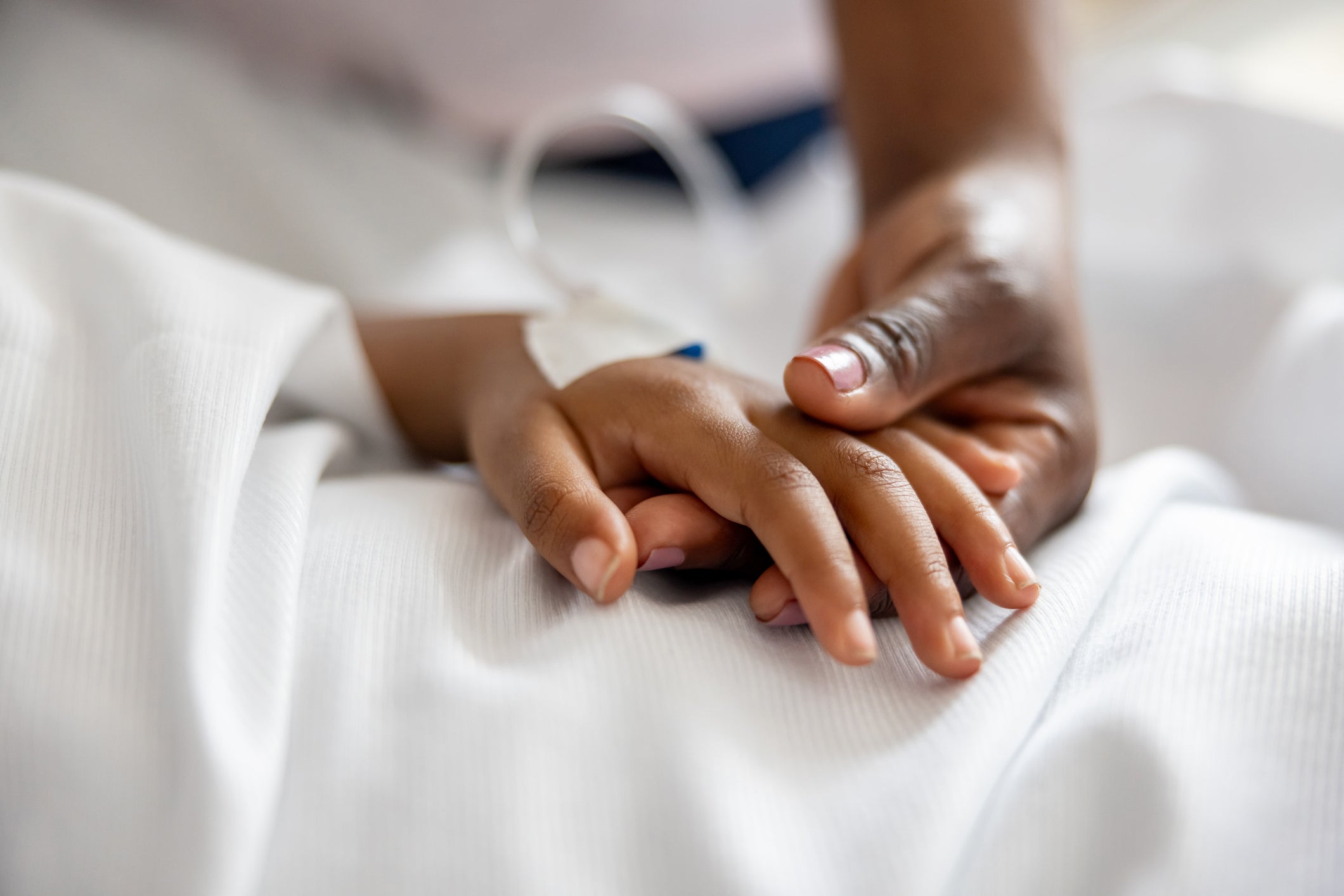 A mother holds her daughter’s hand at the hospital. A quarter of pedatric deaths at hospitals are preventable, a new study found