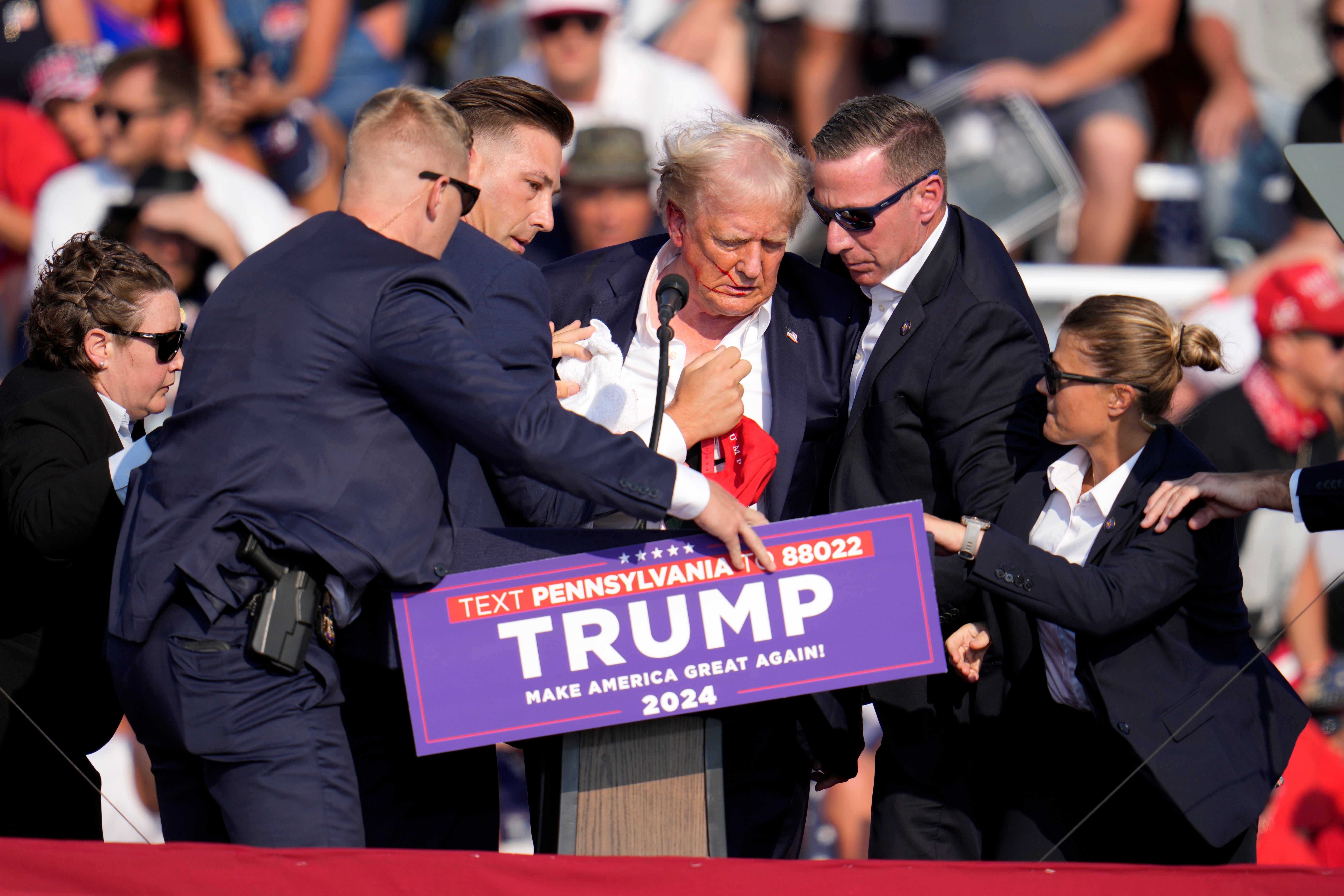 Secret Service agents rush Donald Trump off a stage during a campaign rally in Butler, Pennsylvania, after a gunman fired into the crowd and struck the former president’s ear.