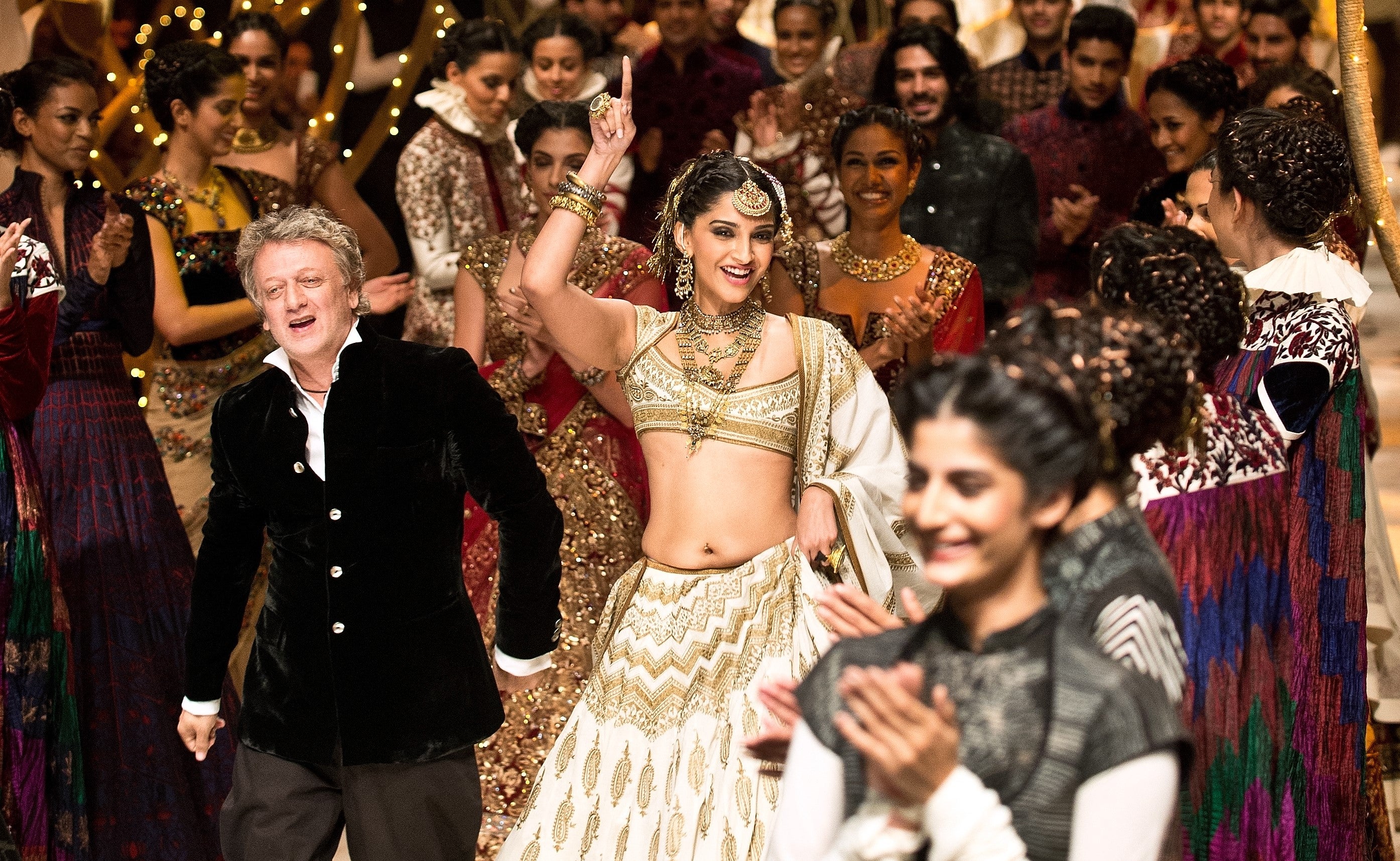 Bollywood actress Sonam Kapoor (C) shows creations by Indian fashion designer Rohit Bal (L) during Indian Bridal Fashion Week in New Delhi on July 26,2013