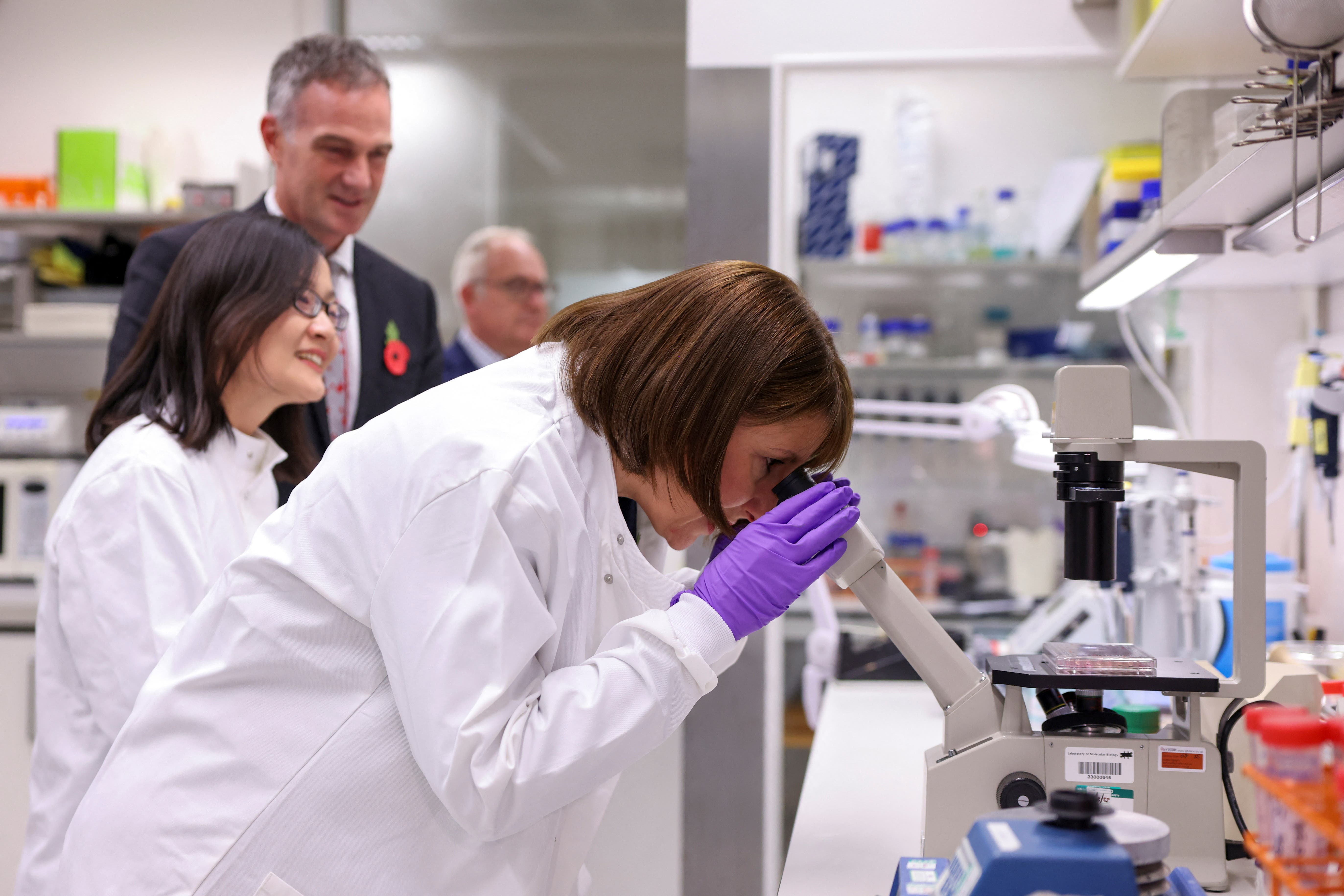 Rachel Reeves looks through a microscope during a visit to a Laboratory For Molecular Biology at Cambridge Biomedical Campus (Hollie Adams/PA)