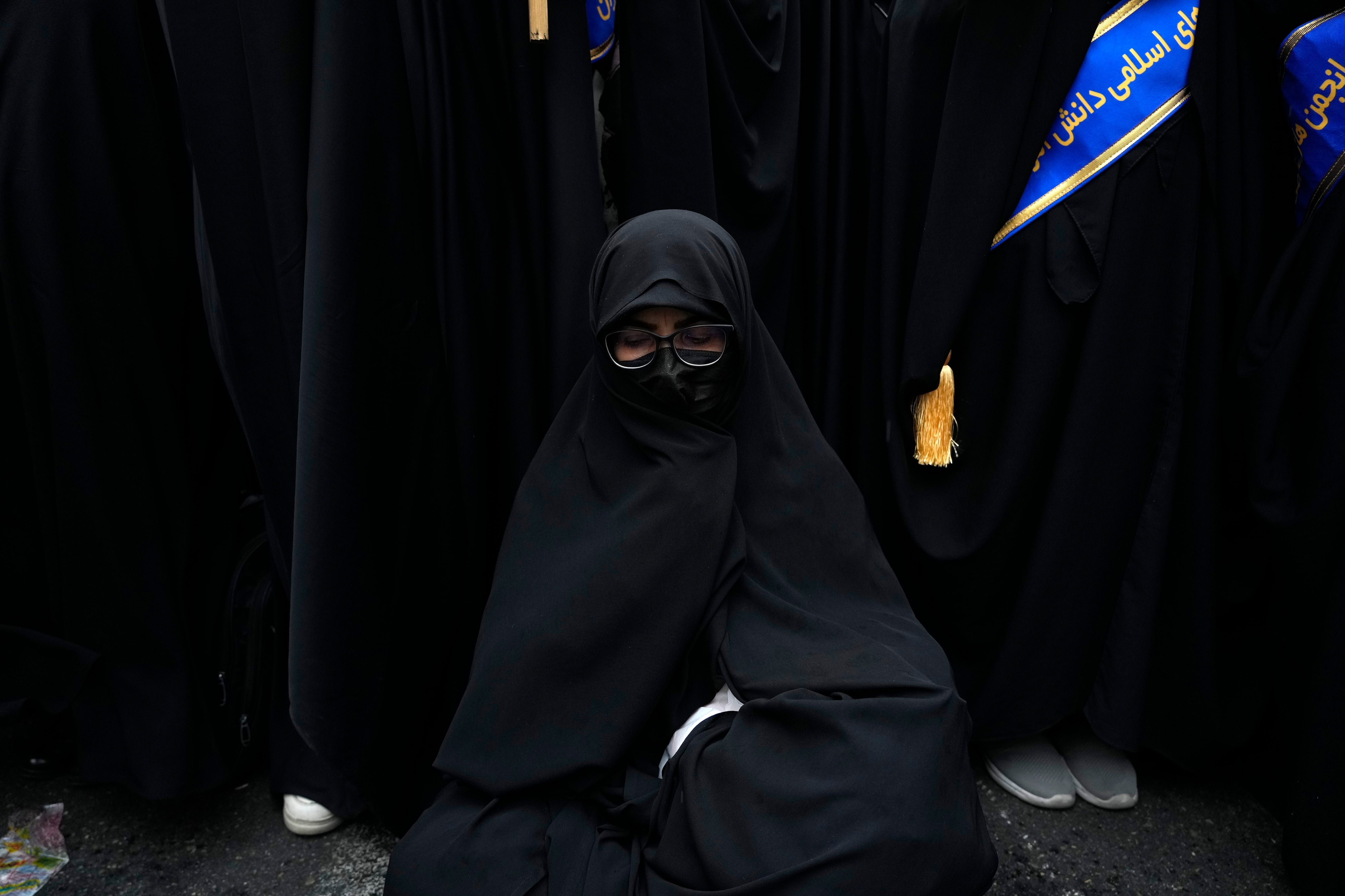 An Iranian woman sits as she attends an annual rally in front of the former U.S. Embassy in Tehran, Iran, Sunday, Nov. 3, 2024, marking the 45th anniversary of Iranian students' takeover of the embassy, starting a hostage crisis