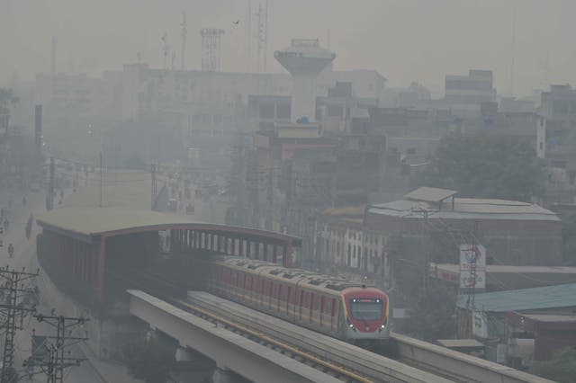 <p>A train travels along an urban line in Lahore, Pakistan, 3 November 2024, amidst alarming levels of air pollution</p>