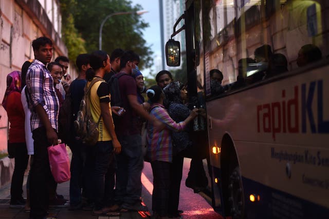 <p>Representational: Malaysians stand in a queue as they board a public transport bus at dusk in Kuala Lumpur on 25 April 2017</p>